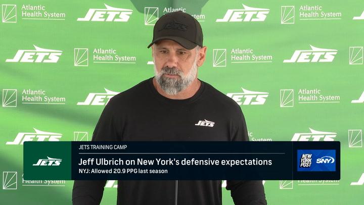 Man in Jets gear at podium.