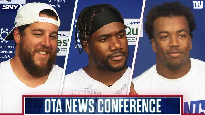 Three athletes at a press event.