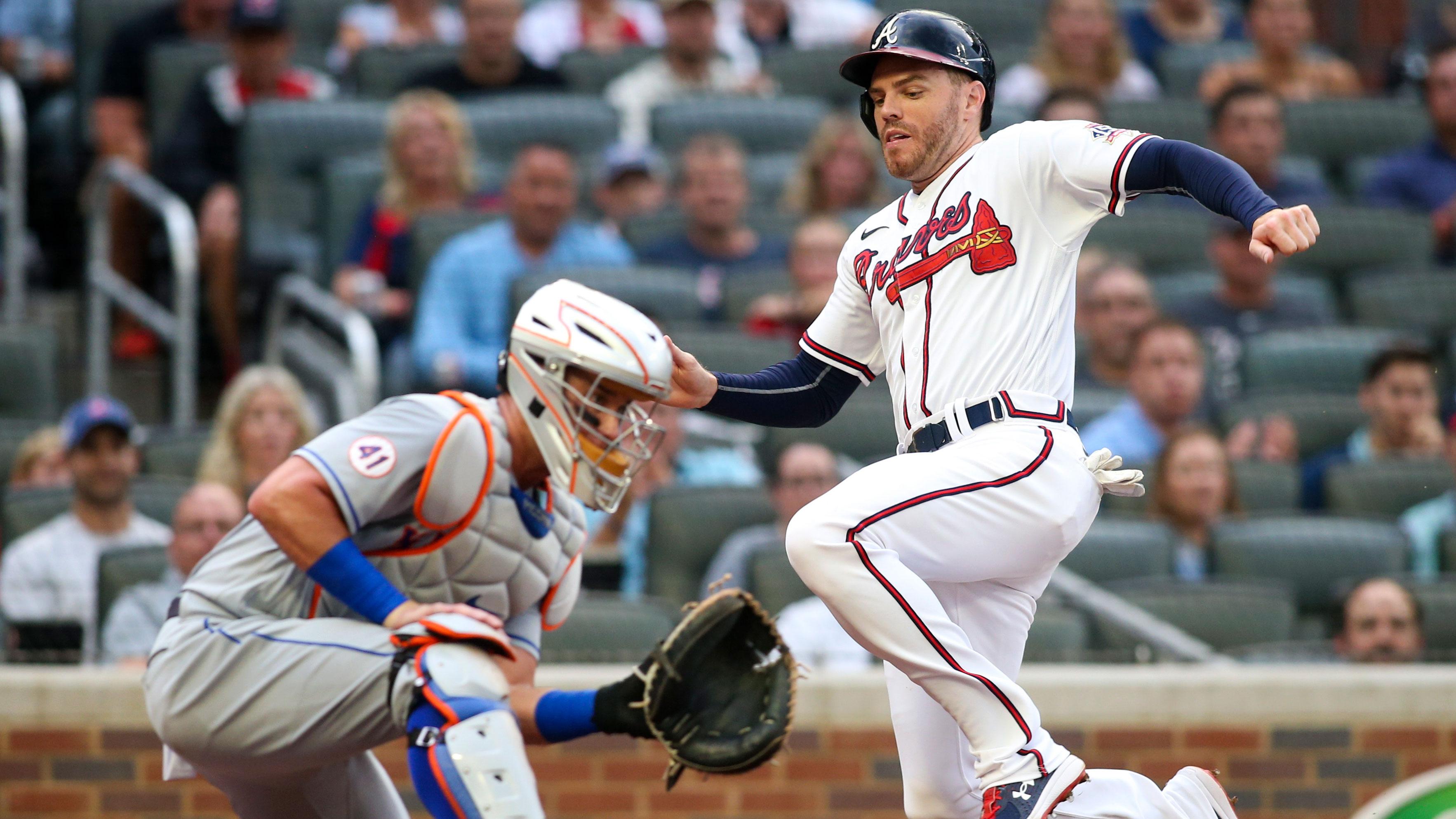 Jun 30, 2021; Atlanta, Georgia, USA; Atlanta Braves first baseman Freddie Freeman (5) slides safely past New York Mets catcher James McCann (33) to score a run in the first inning at Truist Park.