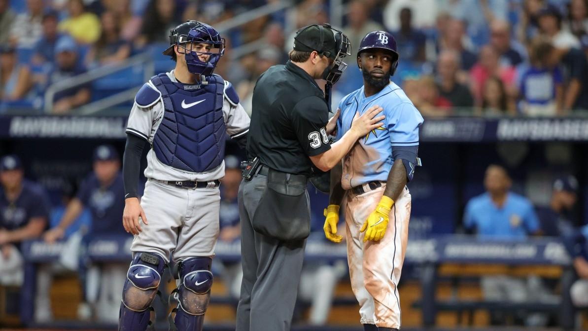 Home plate umpire Mike Estabrook (83) holds back Tampa Bay Rays left fielder Randy Arozarena (56) after being hit by a pitch against the New York Yankees in the eighth inning at Tropicana Field.