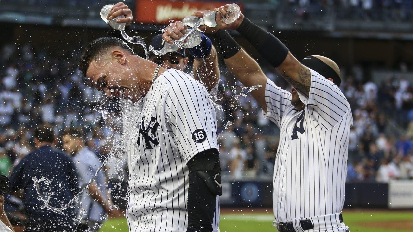 Oct 3, 2021; Bronx, New York, USA; New York Yankees right fielder Aaron Judge (99) is doused with water after his game winning RBI single to defeat the Tampa Bay Rays 1-0 and clinch a wildcard playoff spot at Yankee Stadium. / Wendell Cruz-USA TODAY Sports