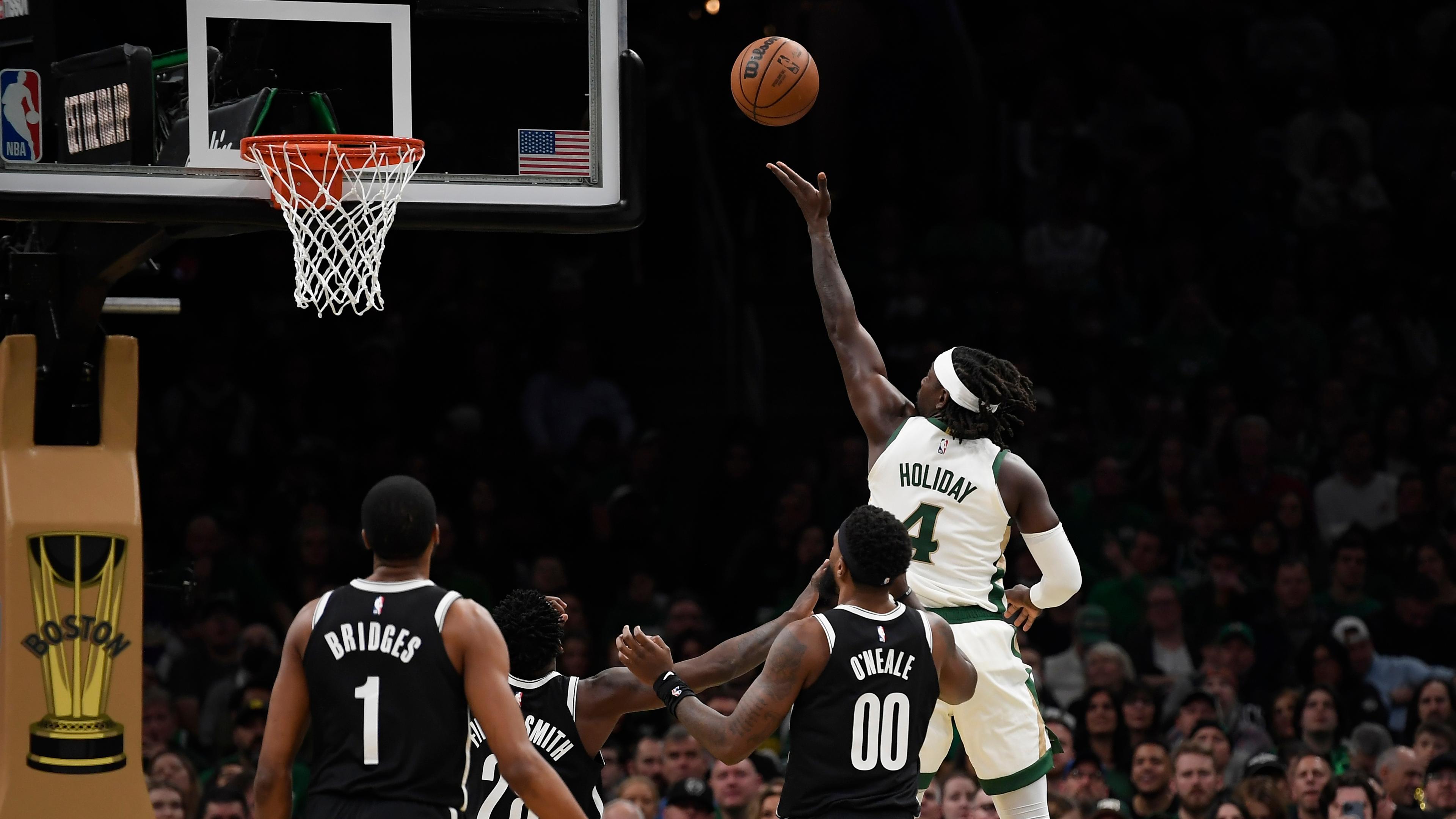 Boston Celtics guard Jrue Holiday (4) drives to the basket while Brooklyn Nets forward Royce O'Neale (00) looks on during the first half at TD Garden.