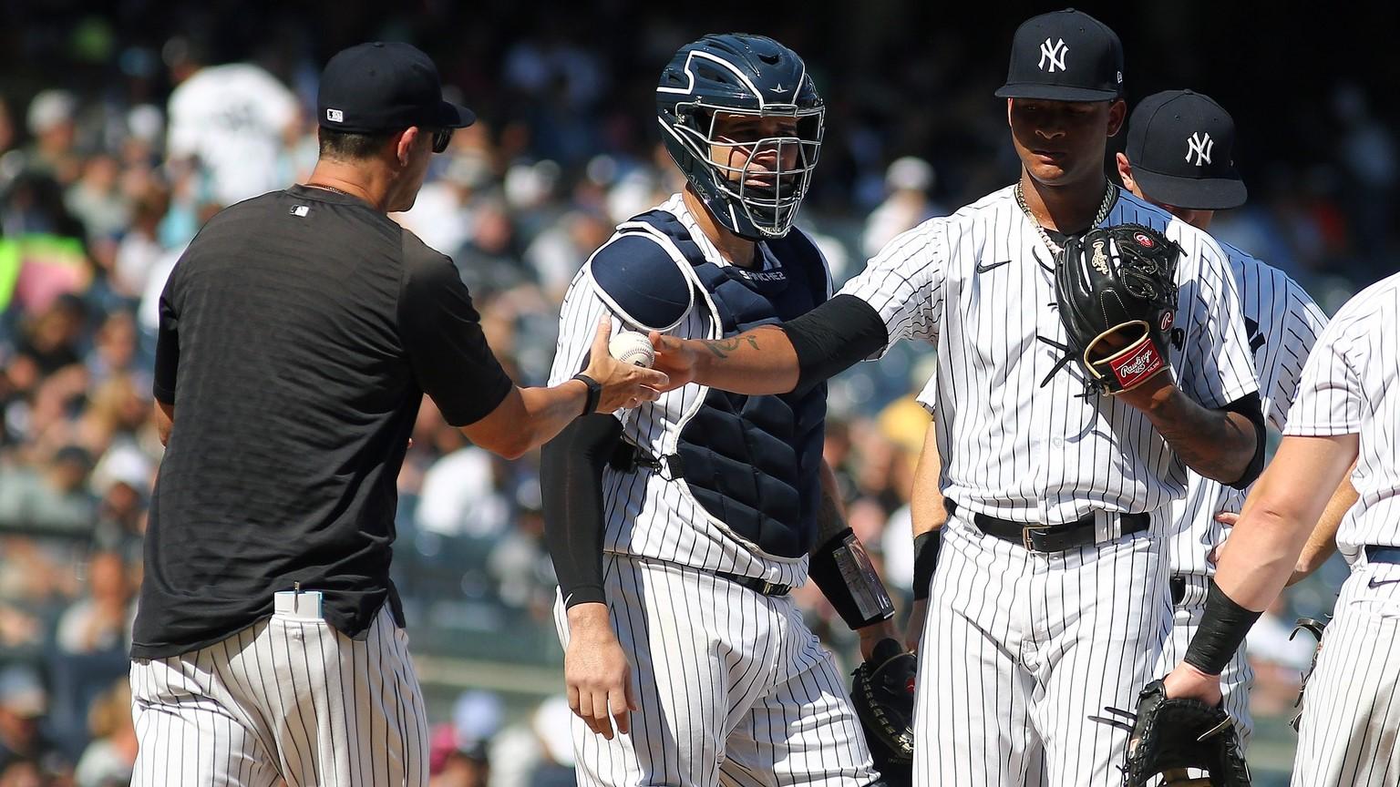 Sep 18, 2021; Bronx, New York, USA; New York Yankees starting pitcher Luis Gil (81) hands the ball to manager Aaron Boone (17) after being taken out of the game against the Cleveland Indians during the fifth inning at Yankee Stadium.