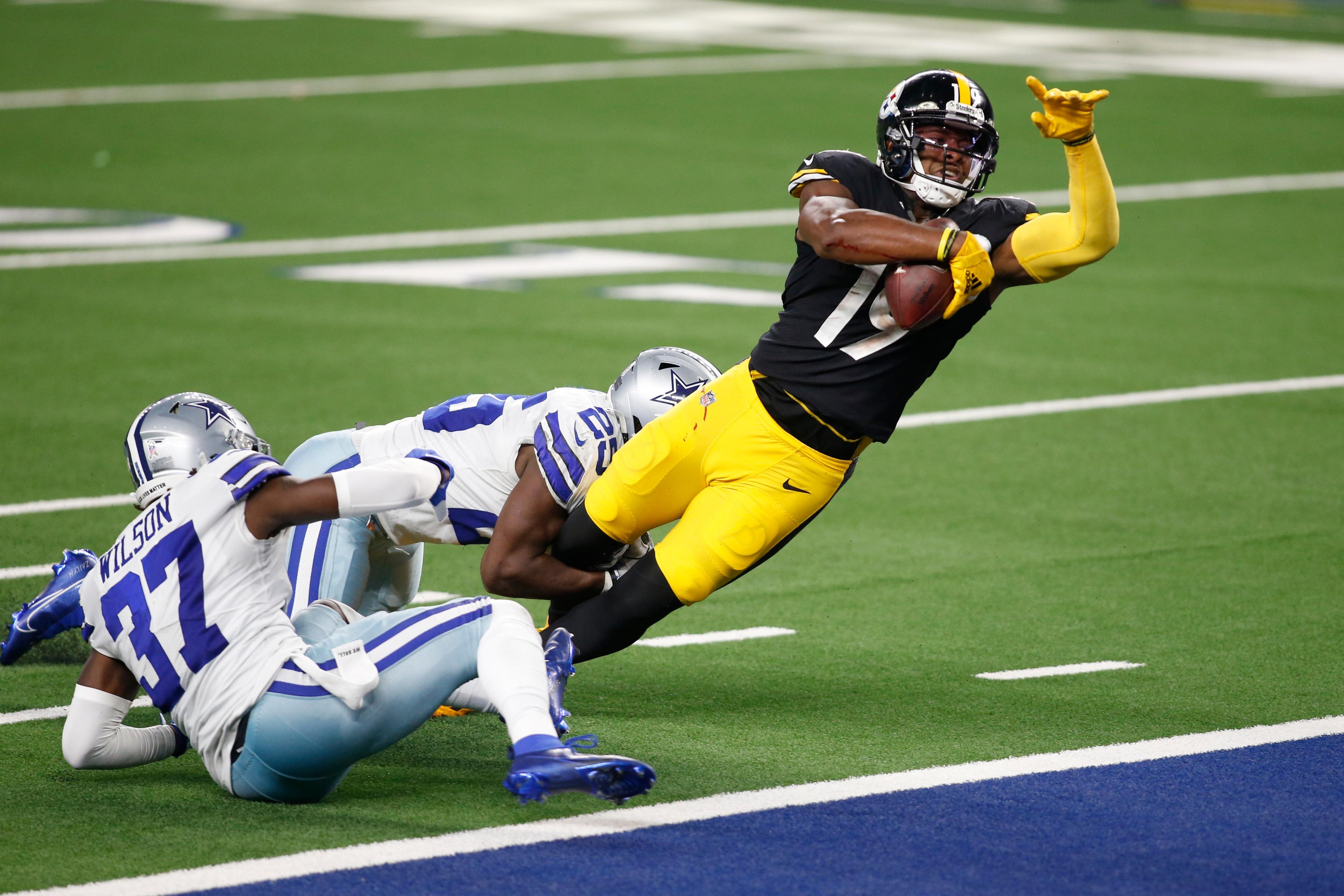 Nov 8, 2020; Arlington, Texas, USA; Pittsburgh Steelers wide receiver JuJu Smith-Schuster (19) catches a pass and runs for a touchdown against Dallas Cowboys free safety Xavier Woods (25) and safety Donovan Wilson (37) in the fourth quarter at AT&T Stadium.