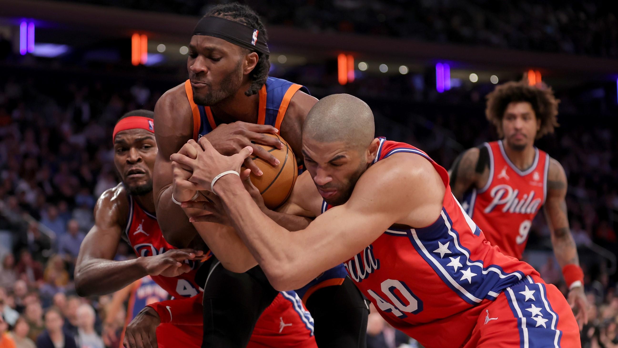 Mar 10, 2024; New York, New York, USA; New York Knicks forward Precious Achiuwa (5) fights for a rebound against Philadelphia 76ers forwards Paul Reed (44) and Nicolas Batum (40) during the fourth quarter at Madison Square Garden.