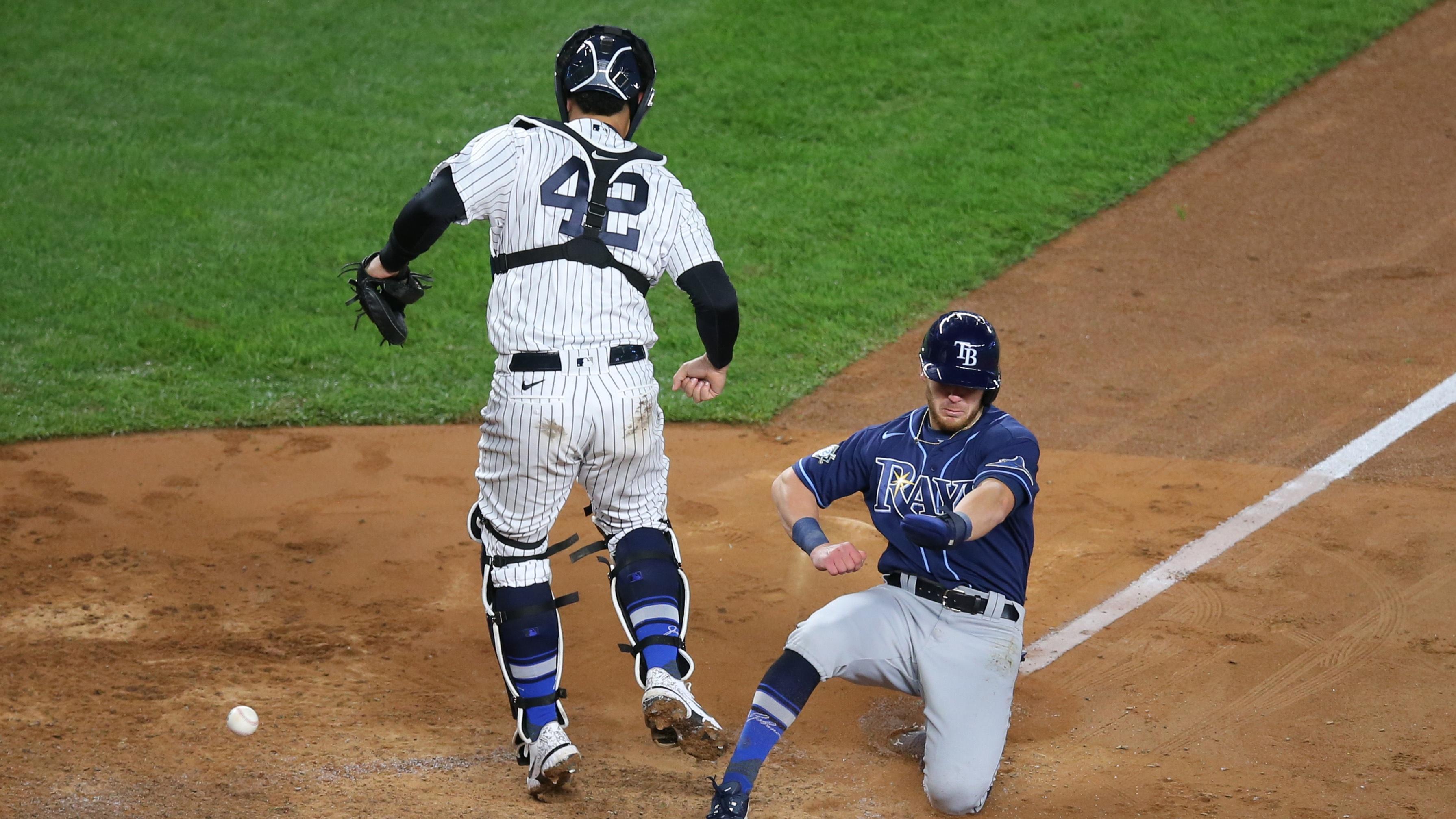 Apr 16, 2021; Bronx, New York, USA; Tampa Bay Rays second baseman Brandon Lowe scores in front of New York Yankees catcher Gary Sanchez after a fielding error by Yankees third baseman Gio Urshela (not pictured) on a ball hit by Rays shortstop Willy Adames (not pictured) during the fifth inning at Yankee Stadium. Mandatory Credit: Brad Penner-USA TODAY Sports