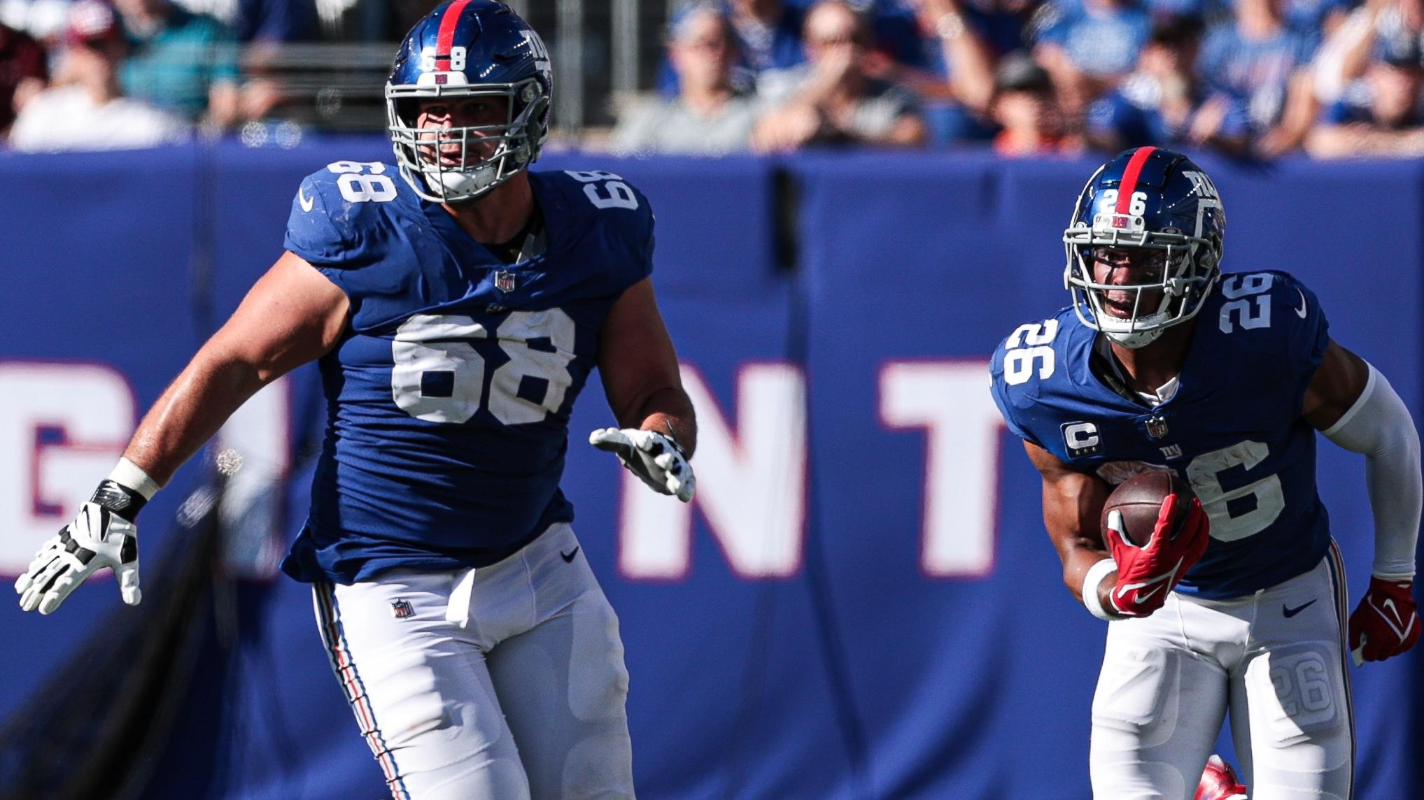 New York Giants running back Saquon Barkley (26) gains yards after the catch as New York Giants offensive guard Ben Bredeson (68) blocks against the Atlanta Falcons during the second half at MetLife Stadium