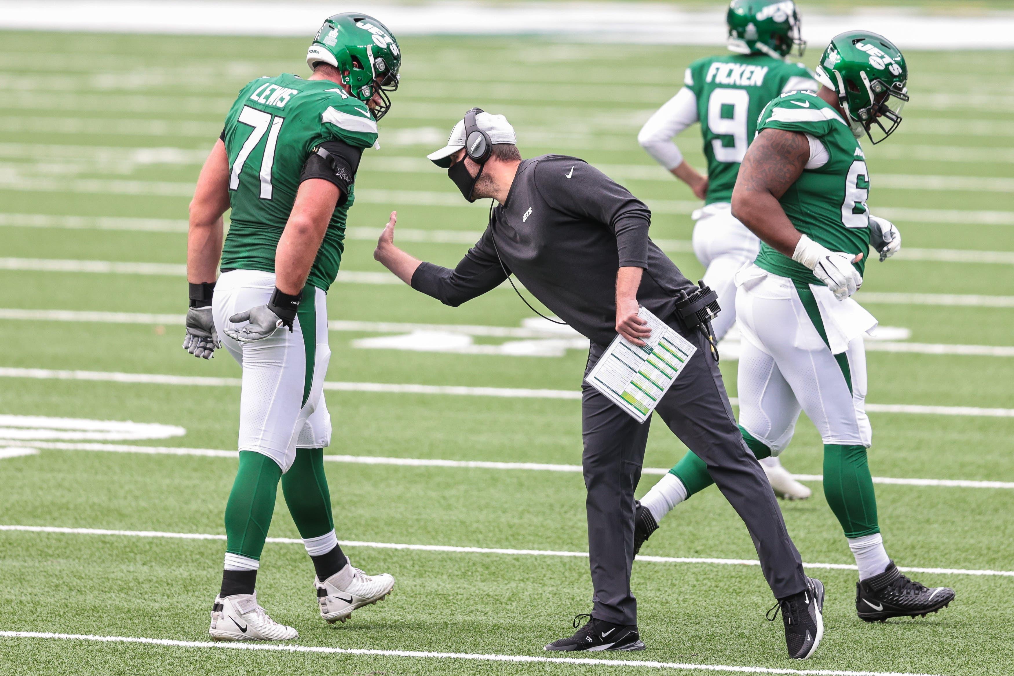 Oct 11, 2020; East Rutherford, New Jersey, USA; New York Jets head coach Adam Gase, right, attempts to slap hands with offensive guard Alex Lewis (71) during the second half against the Arizona Cardinals at MetLife Stadium. Mandatory Credit: Vincent Carchietta-USA TODAY Sports / © Vincent Carchietta-USA TODAY Sports