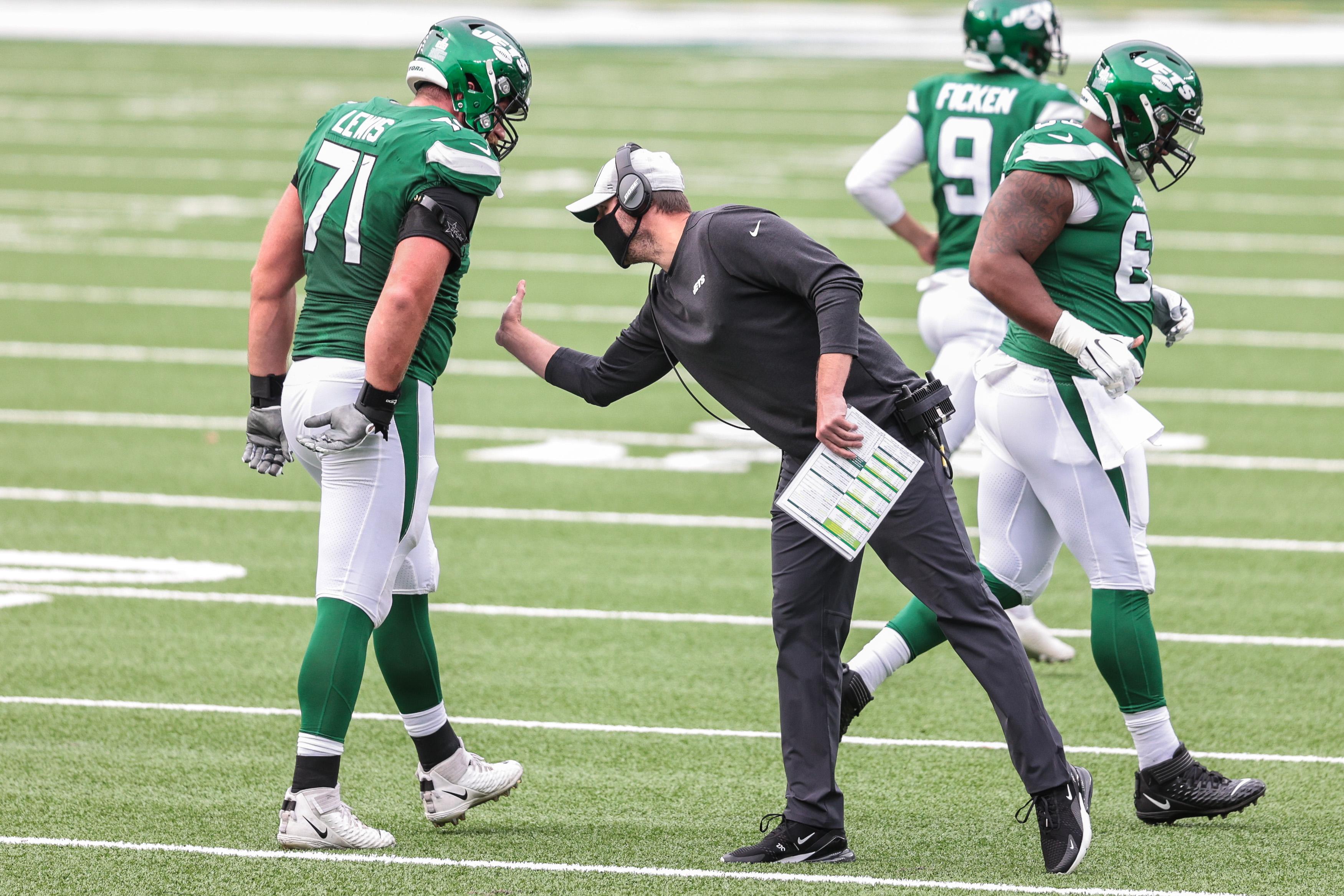 Oct 11, 2020; East Rutherford, New Jersey, USA; New York Jets head coach Adam Gase, right, attempts to slap hands with offensive guard Alex Lewis (71) during the second half against the Arizona Cardinals at MetLife Stadium. Mandatory Credit: Vincent Carchietta-USA TODAY Sports