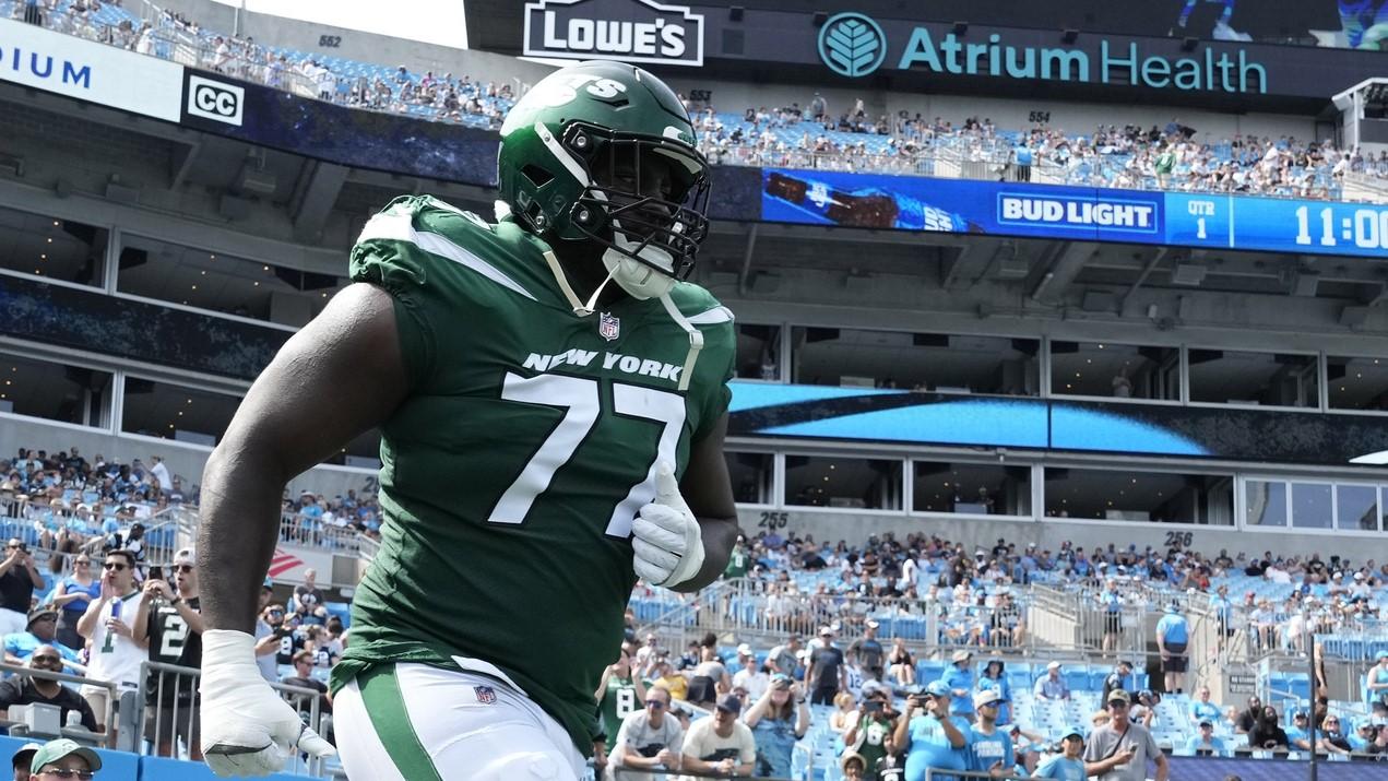 Aug 12, 2023; Charlotte, North Carolina, USA; New York Jets offensive tackle Mekhi Becton (77) runs on to the field in before the game at Bank of America Stadium.