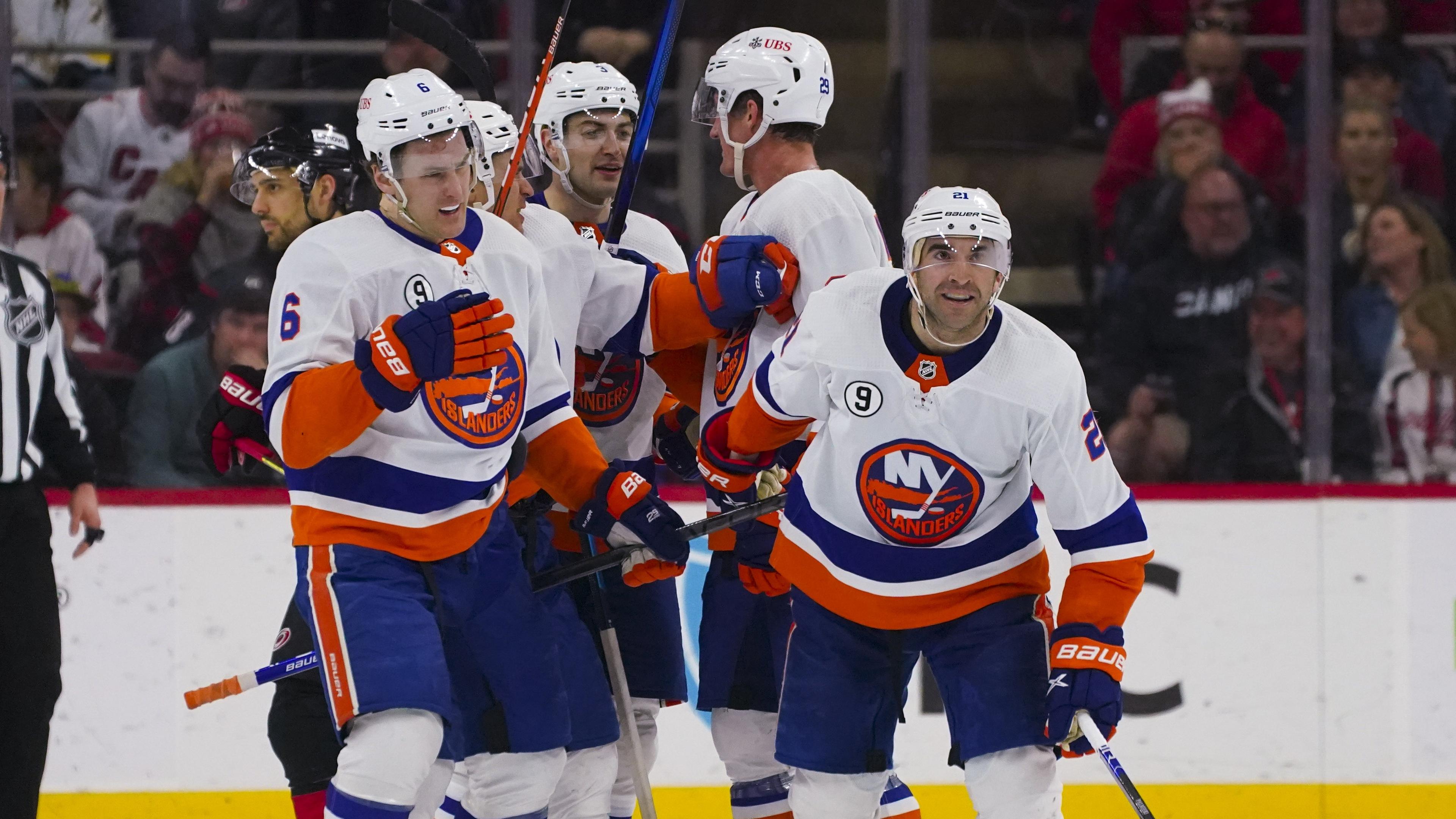 Apr 8, 2022; Raleigh, North Carolina, USA; New York Islanders right wing Kyle Palmieri (21) is congratulated by defenseman Ryan Pulock (6) center Brock Nelson (29) defenseman Adam Pelech (3) and left wing Zach Parise (11) after his goal against the Carolina Hurricanes during the third period at PNC Arena. Mandatory Credit: James Guillory-USA TODAY Sports