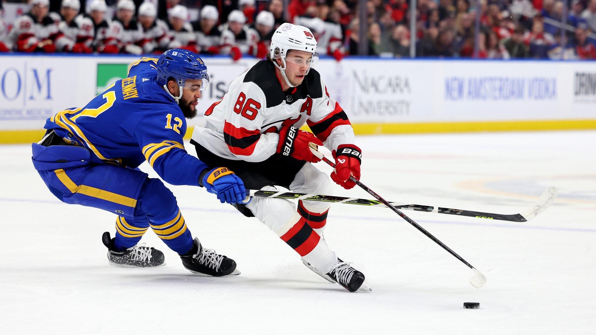 Mar 29, 2024; Buffalo, New York, USA; New Jersey Devils center Jack Hughes (86) carries the puck as Buffalo Sabres left wing Jordan Greenway (12) tries to defend during the first period at KeyBank Center.