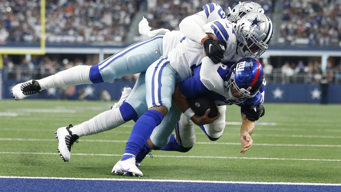 Oct 10, 2021; Arlington, Texas, USA; New York Giants quarterback Daniel Jones (8) is tackled by Dallas Cowboys linebacker Jabril Cox (14) and defensive end Chauncey Golston (59) in the second quarter at AT&T Stadium.