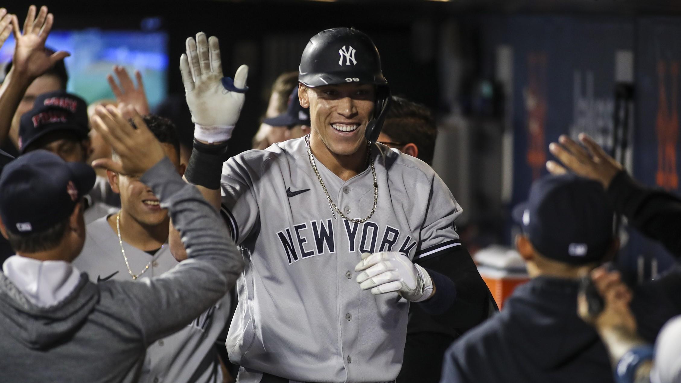 Yankees right fielder Aaron Judge (99) is greeted in the dugout after hitting a solo home run in the second inning against the New York Mets at Citi Field.