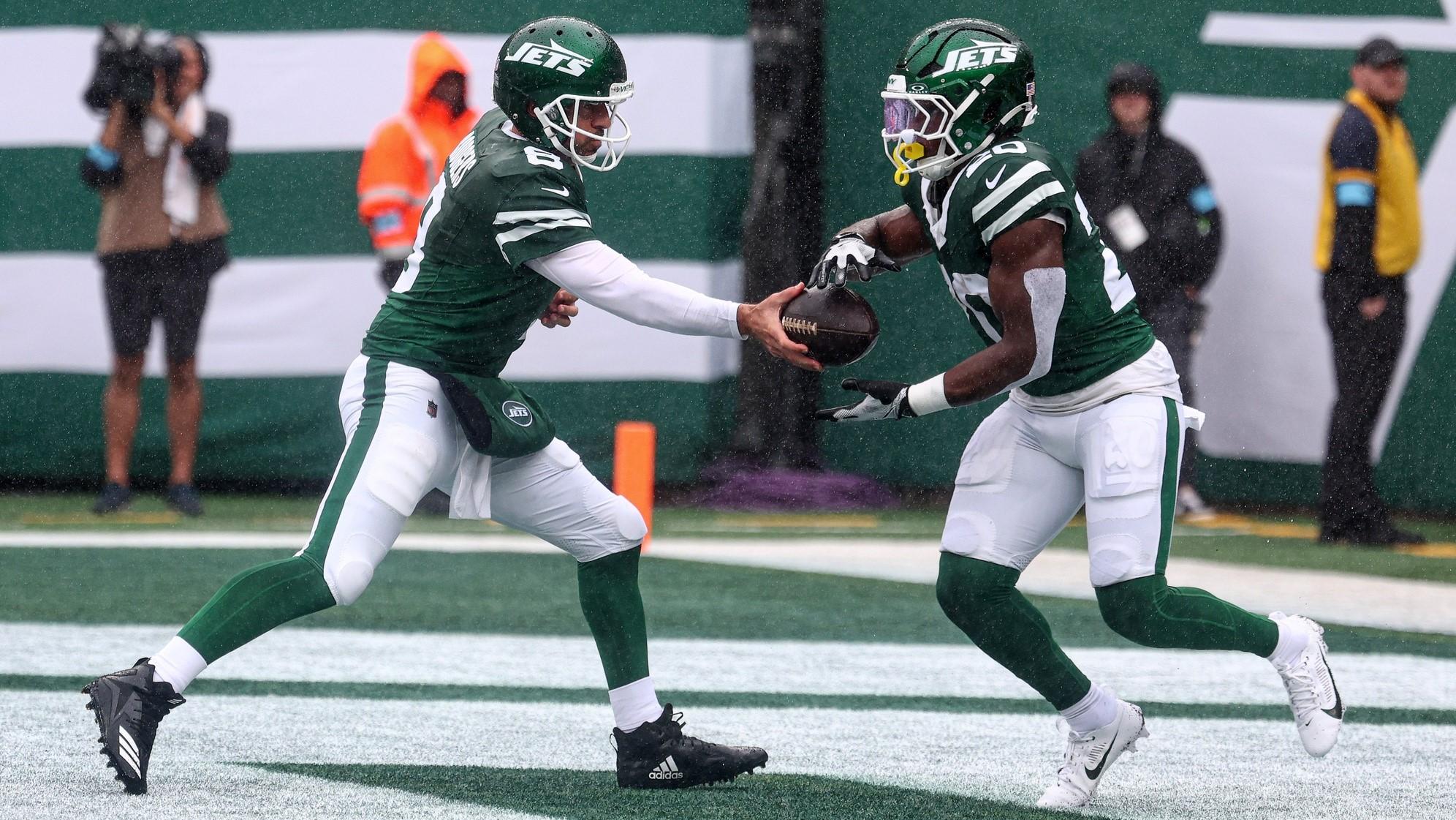 Sep 29, 2024; East Rutherford, New Jersey, USA; New York Jets quarterback Aaron Rodgers (8) hands off to running back Breece Hall (20) during the first half against the Denver Broncos at MetLife Stadium.