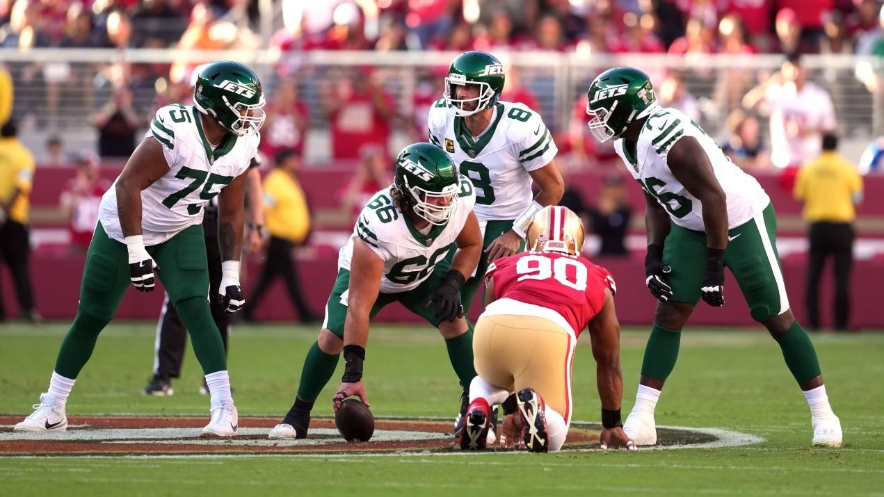 New York Jets quarterback Aaron Rodgers (8) talks with guards Alijah Vera-Tucker (75) and John Simpson (76) and center Joe Tippmann (66) before a snap against the San Francisco 49ers during the first quarter at Levi's Stadium.