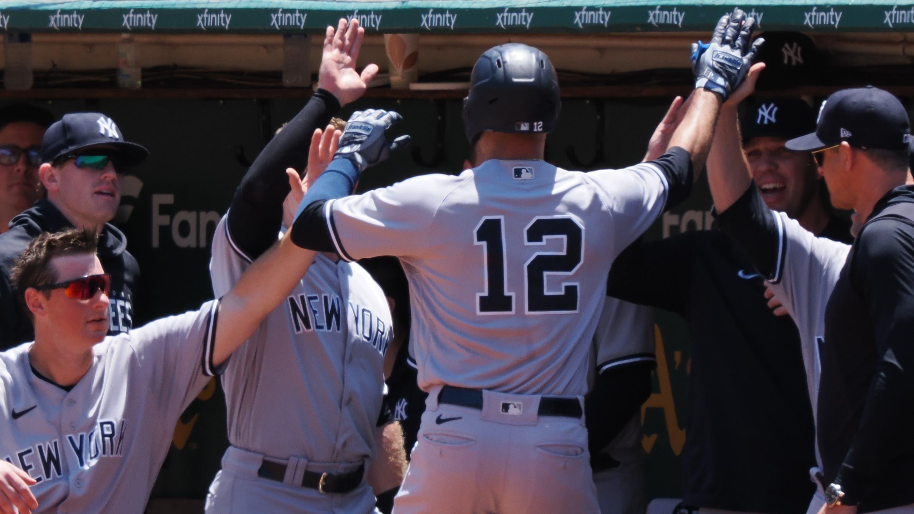 New York Yankees left fielder Isiah Kiner-Falefa (12) high fives teammates after hitting a solo home run against the Oakland Athletics during the second inning at Oakland-Alameda County Coliseum / Kelley L Cox - USA TODAY Sports