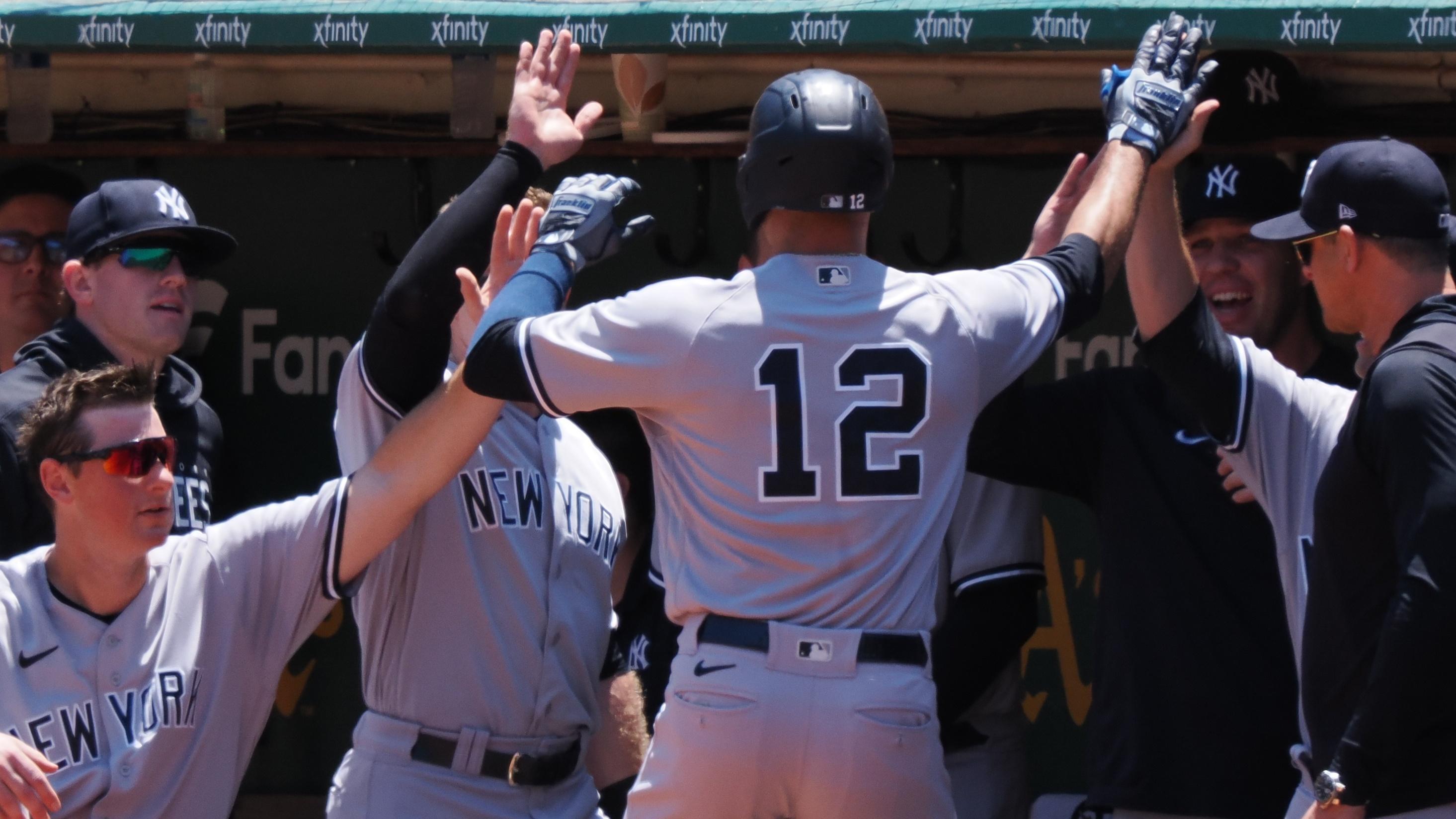 New York Yankees left fielder Isiah Kiner-Falefa (12) high fives teammates after hitting a solo home run against the Oakland Athletics during the second inning at Oakland-Alameda County Coliseum