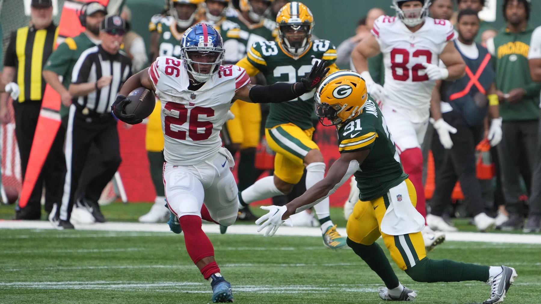 Oct 9, 2022; London, United Kingdom; New York Giants running back Saquon Barkley (26) carries the ball in the second quarter as Green Bay Packers safety Adrian Amos (31) defends during an NFL International Series game at Tottenham Hotspur Stadium.