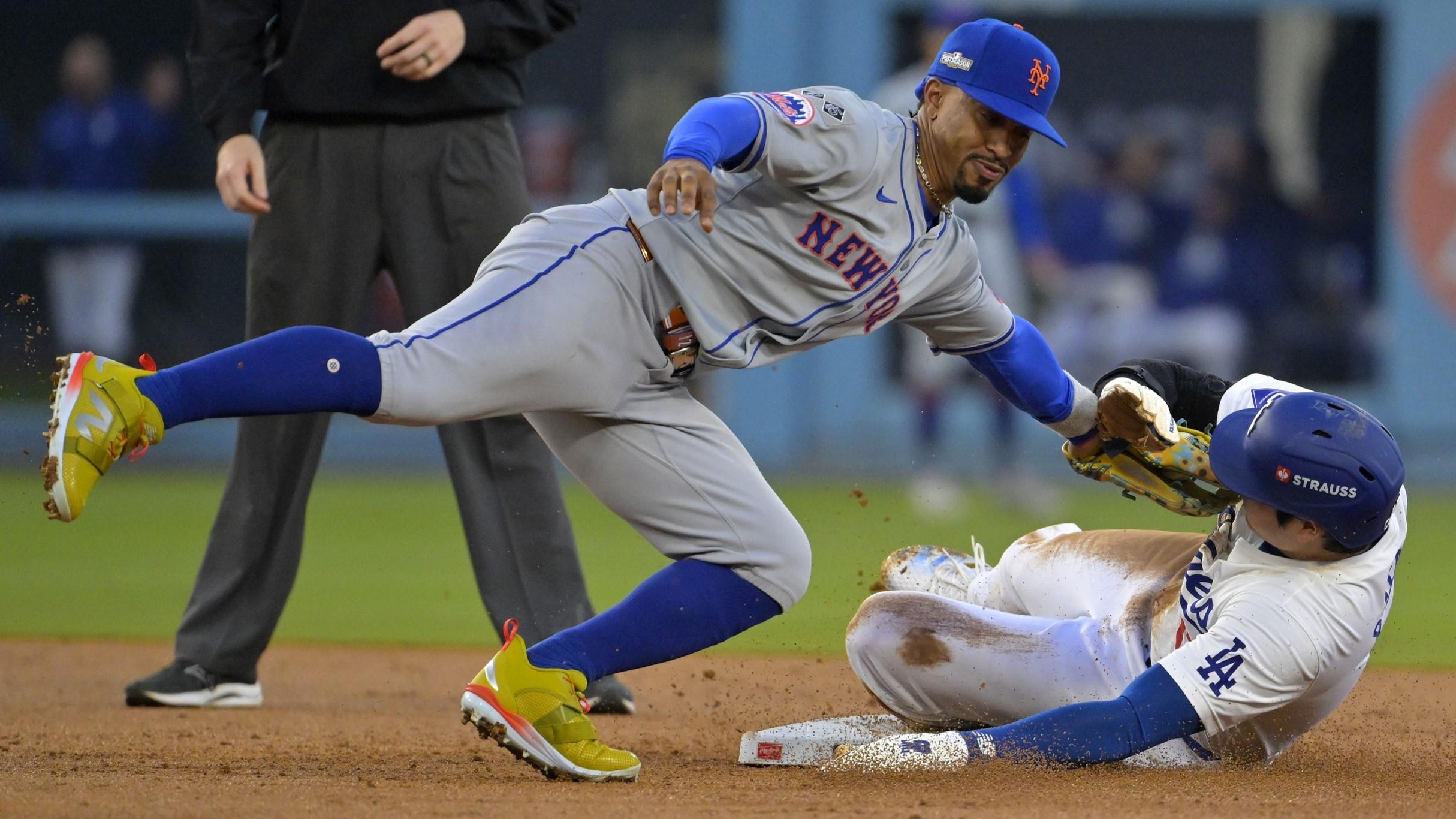 Oct 13, 2024; Los Angeles, California, USA; New York Mets shortstop Francisco Lindor (12) gets the tag on Los Angeles Dodgers two-way player Shohei Ohtani (17) attempting to steal second base in the second inning during game one of the NLCS for the 2024 MLB Playoffs at Dodger Stadium.