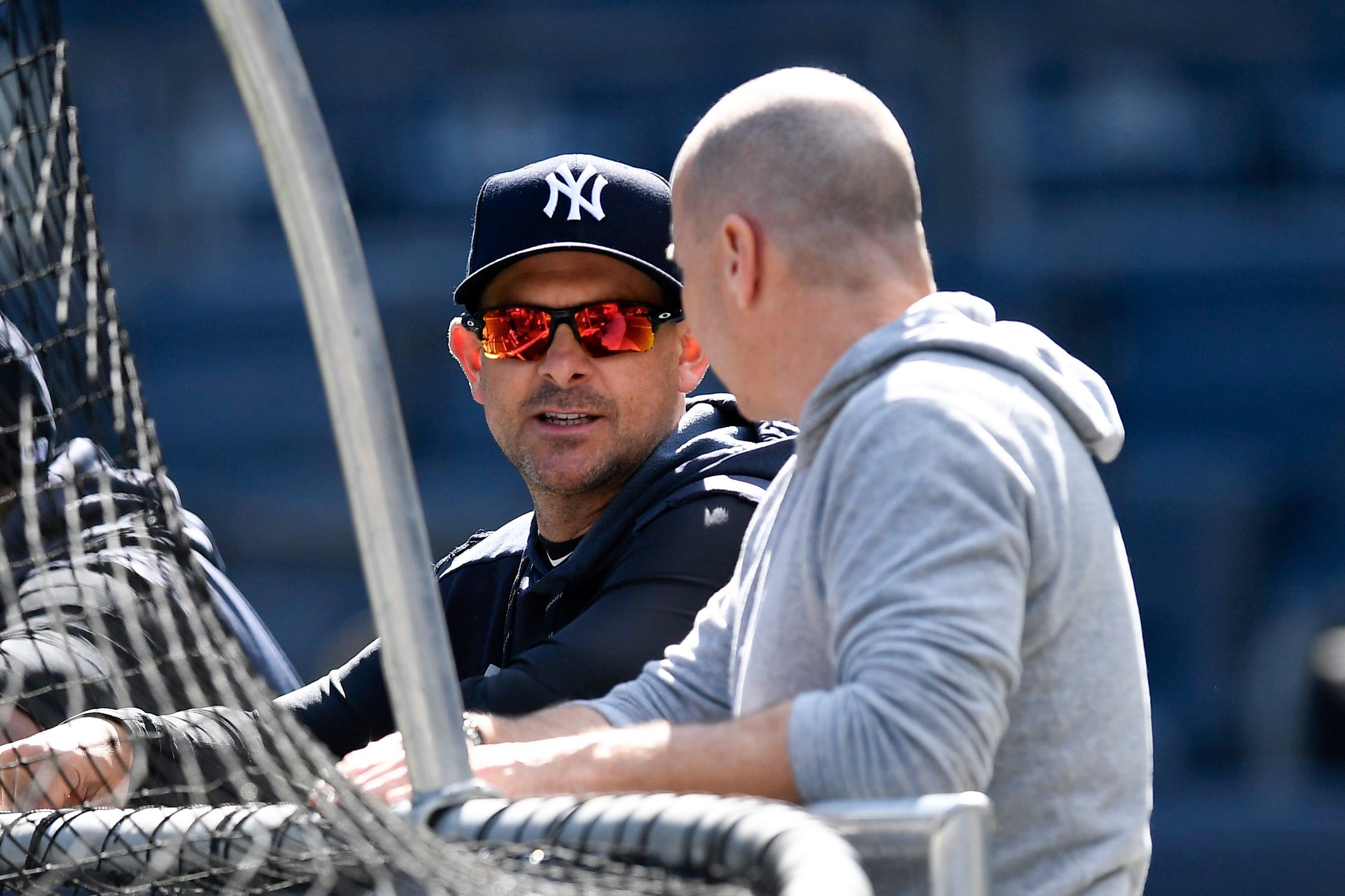 Aaron Boone and Brian Cashman talk at the batting cage