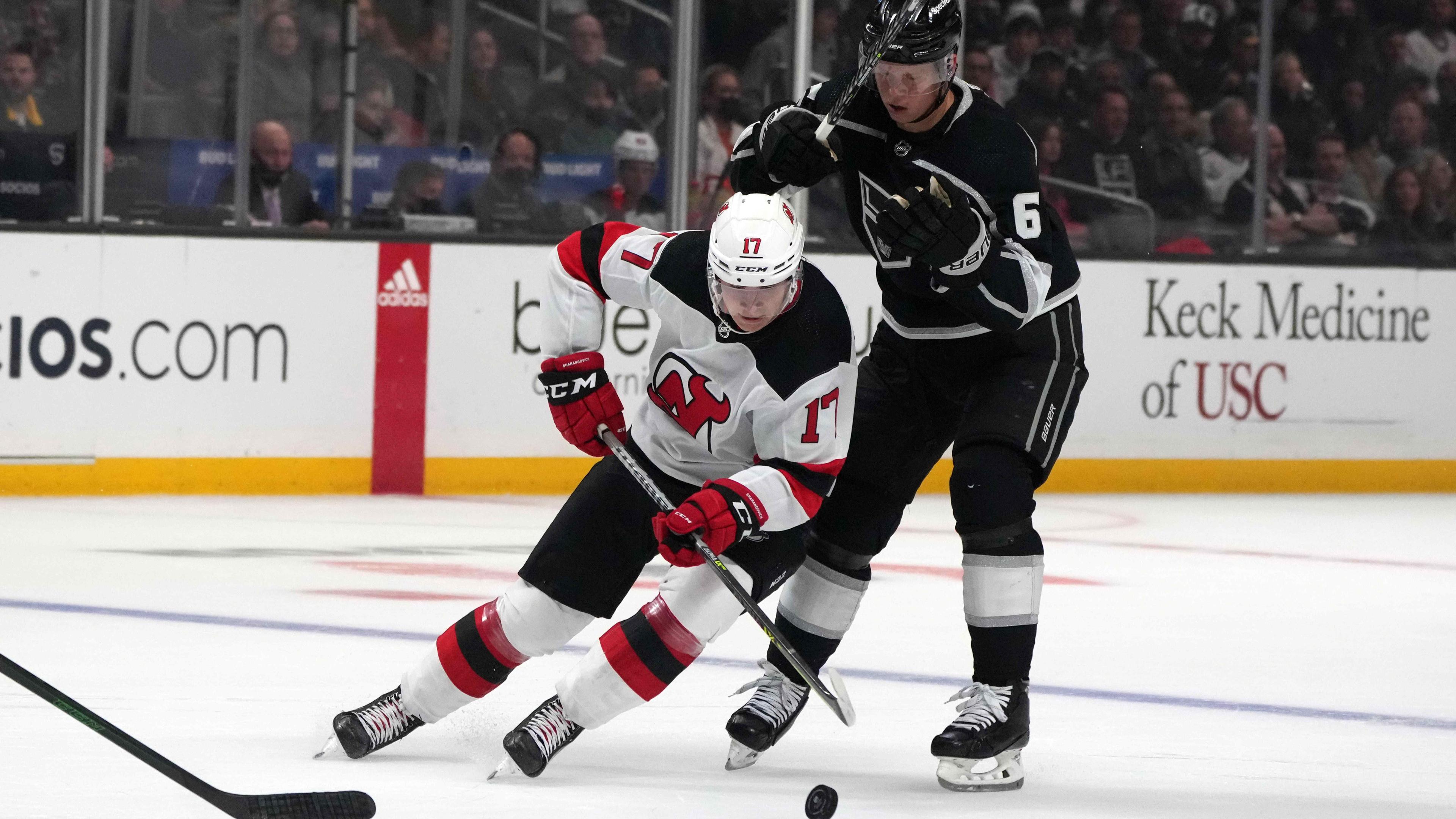 Nov 5, 2021; Los Angeles, California, USA; New Jersey Devils center Yegor Sharangovich (17) battles for the puck with LA Kings defenseman Olli Maatta (6) in the first period at Staples Center.