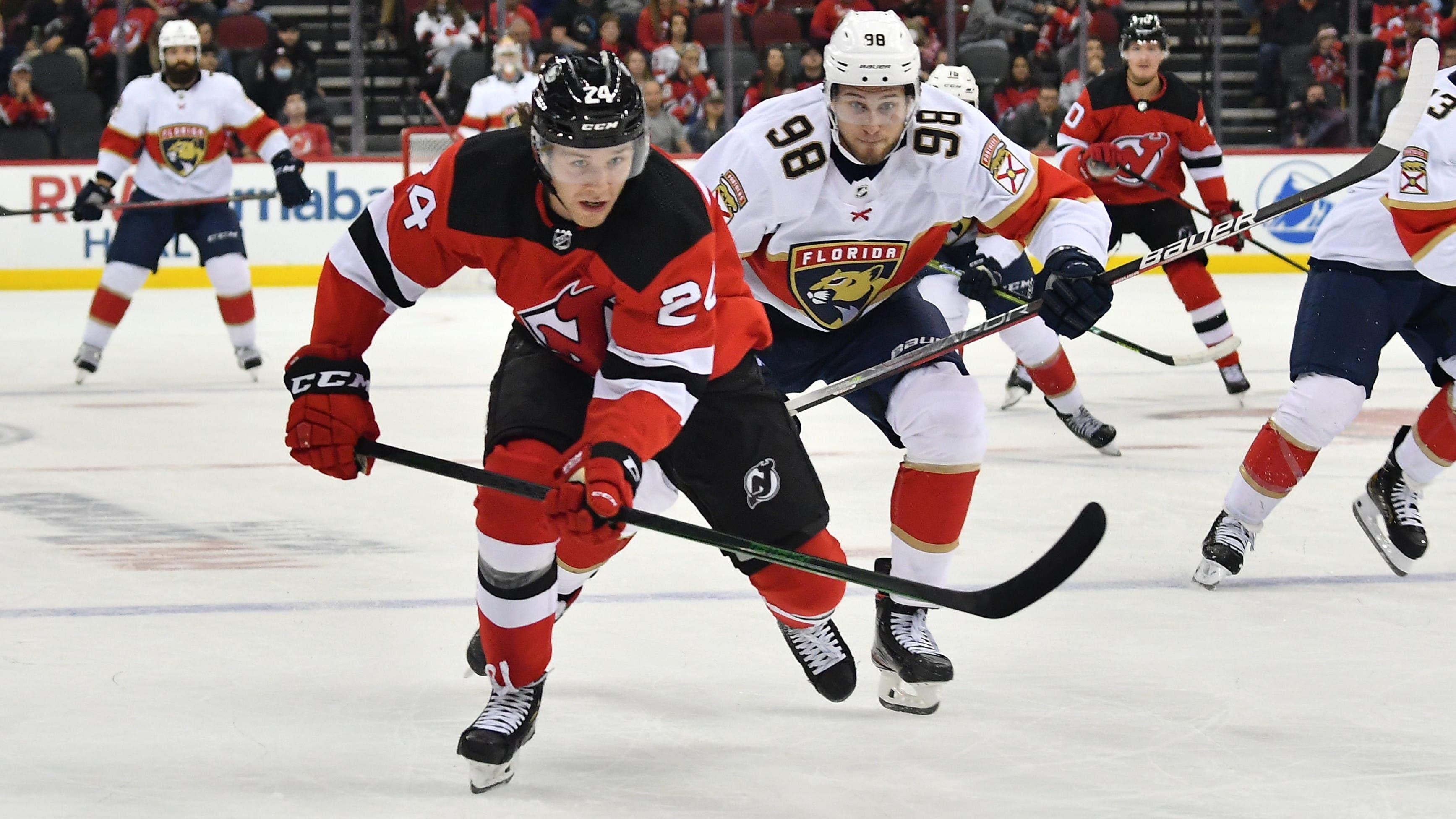 New Jersey Devils defenseman Ty Smith (24) battles for the puck against Florida Panthers center Maxim Mamin (98) during the first period at Prudential Center. / Catalina Fragoso-USA TODAY Sports