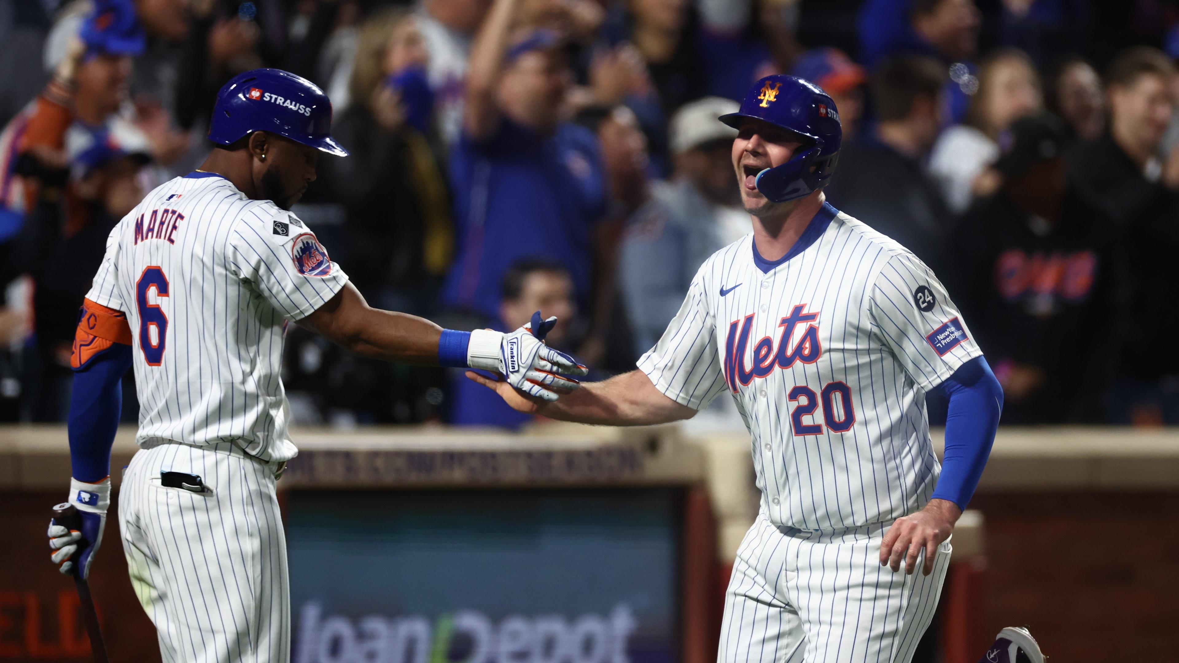 Oct 18, 2024; New York City, New York, USA; New York Mets first baseman Pete Alonso (20) high-fives right fielder Starling Marte (6) after scoring during the fourth inning against the Los Angeles Dodgers during game five of the NLCS for the 2024 MLB playoffs at Citi Field. Mandatory Credit: Vincent Carchietta-Imagn Images