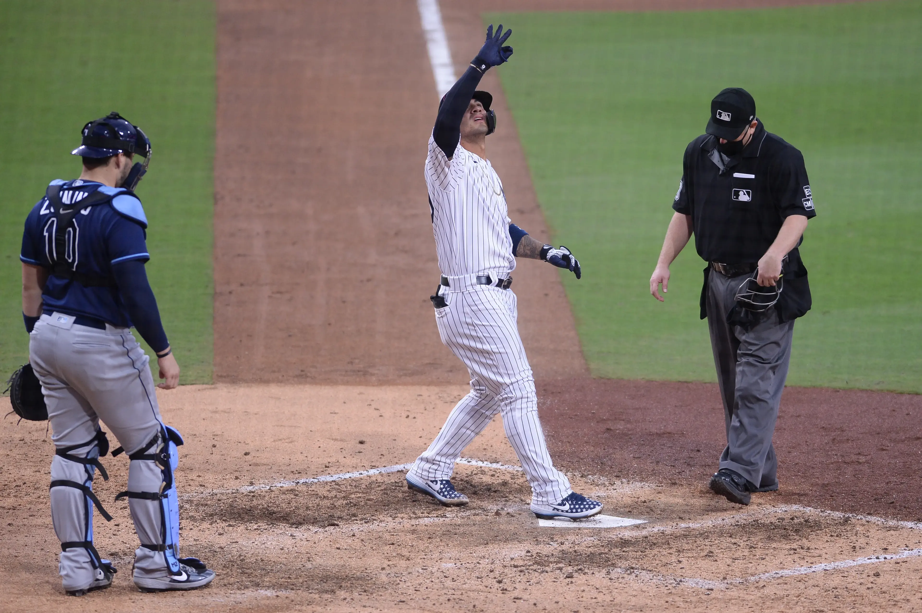 Oct 8, 2020; San Diego, California, USA; New York Yankees shortstop Gleyber Torres (25) touches home plate in front of Tampa Bay Rays catcher Mike Zunino (10) after hitting a two run home run as home plate umpire Todd Tichenor looks on during the sixth inning of game four of the 2020 ALDS at Petco Park. Mandatory Credit: Orlando Ramirez-USA TODAY Sports / © Orlando Ramirez-USA TODAY Sports