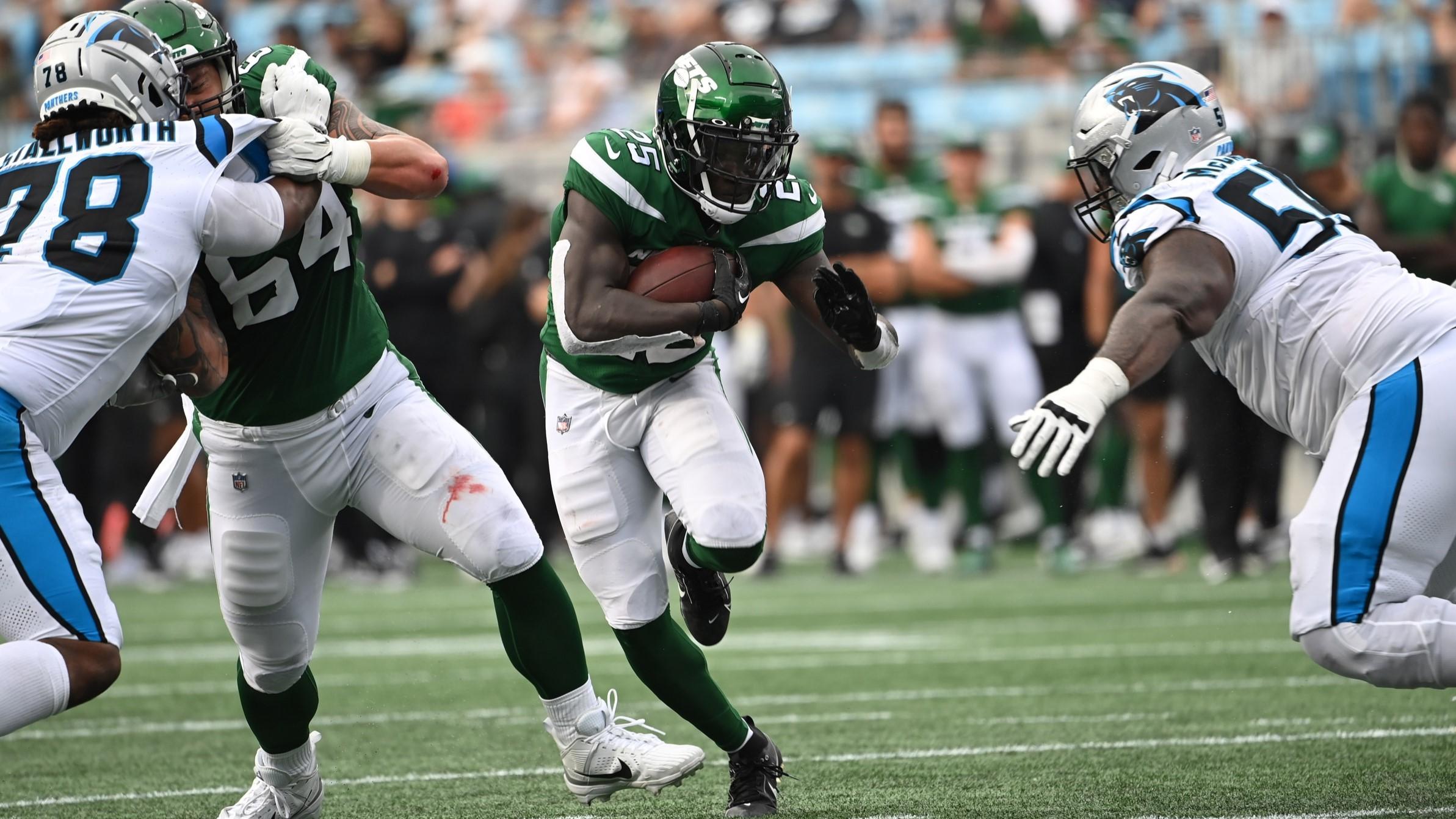 Aug 12, 2023; Charlotte, North Carolina, USA; New York Jets running back Israel Abanikanda (25) with the ball as Carolina Panthers defensive tackles Taylor Stallworth (78) and Marquan McCall (55) defend in the fourth quarter at Bank of America Stadium