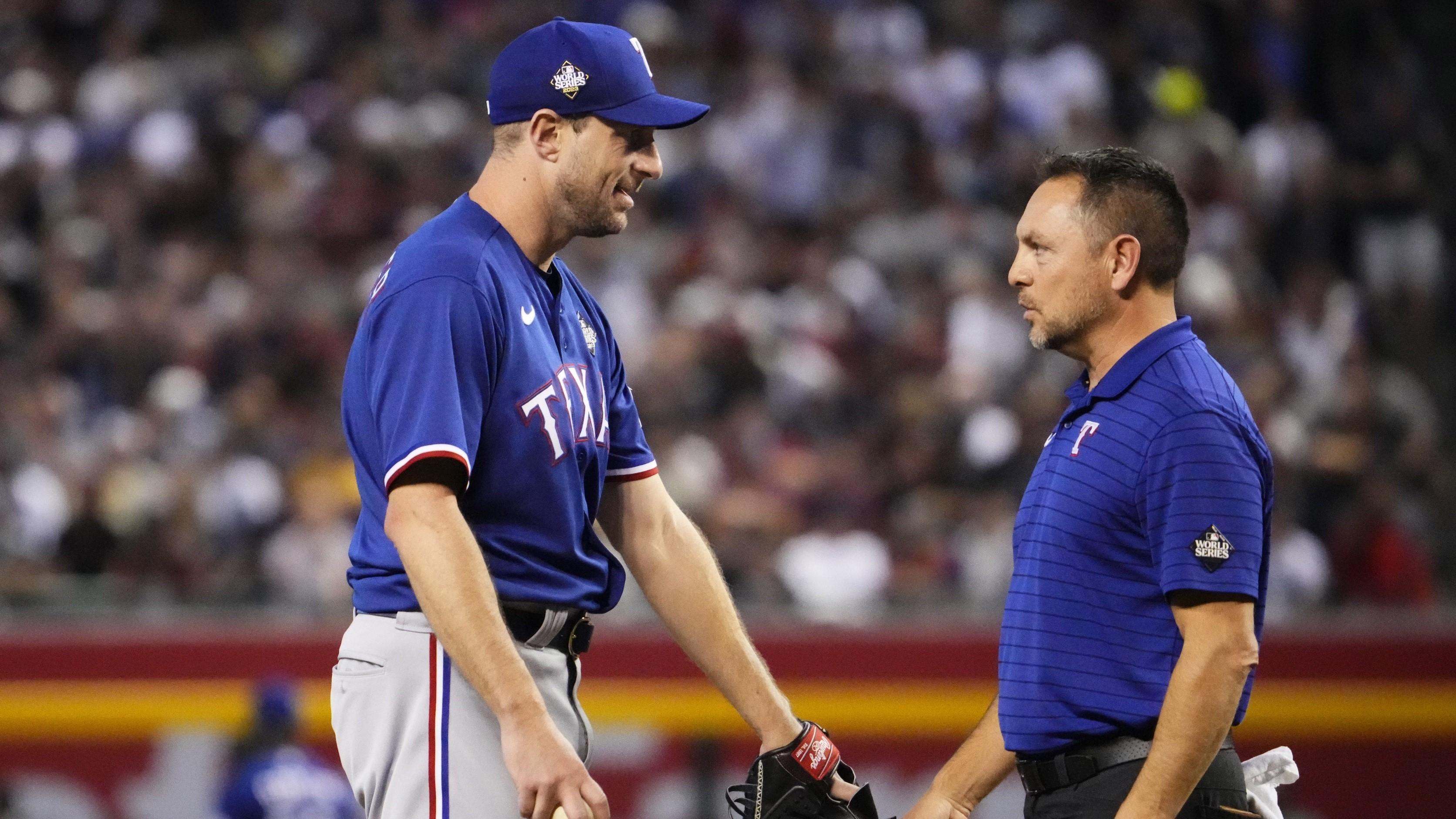 Texas Rangers starting pitcher Max Scherzer (31) talks to a trainer before being removed during the fourth inning against the Arizona Diamondbacks in game three of the 2023 World Series at Chase Field on Oct. 30, 2023, in Phoenix, Arizona.