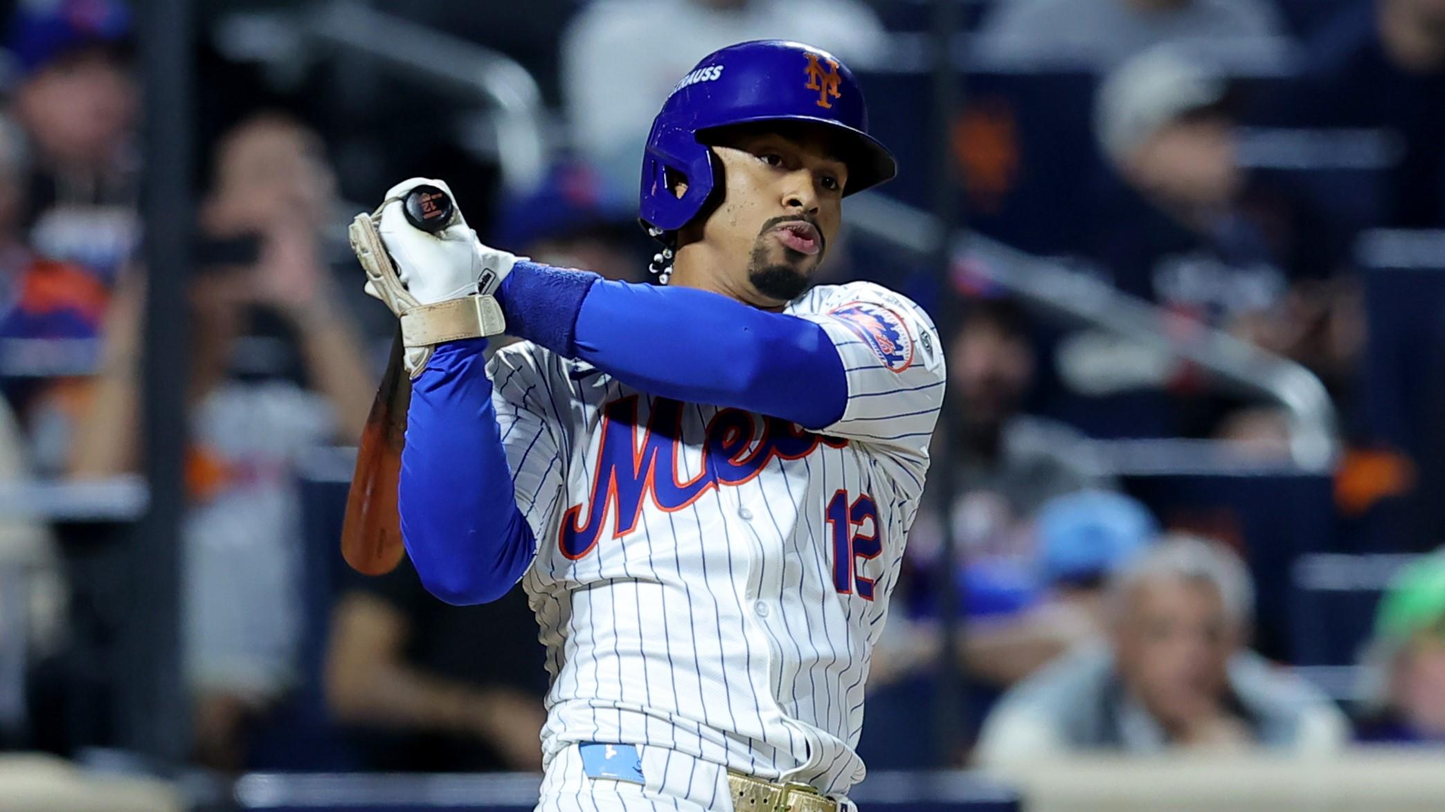 Oct 8, 2024; New York City, New York, USA; New York Mets shortstop Francisco Lindor (12) follows through on an RBI double against the Philadelphia Phillies during the eighth inning of game three of the NLDS in the 2024 MLB Playoffs at Citi Field. 