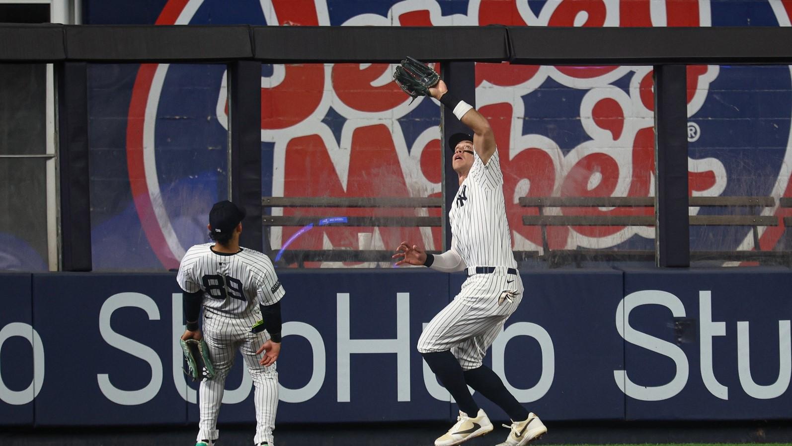 Sep 26, 2024; Bronx, New York, USA; New York Yankees center fielder Aaron Judge (99) makes a catch for an out in front of left fielder Jasson Dominguez (89) during the first inning against the Baltimore Orioles at Yankee Stadium.