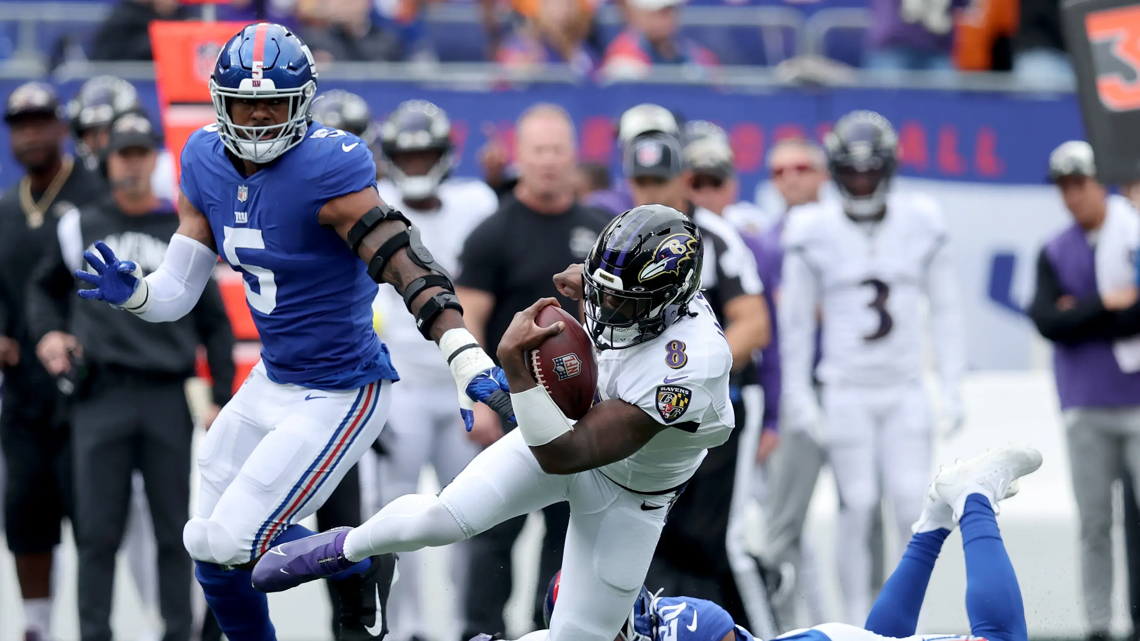 Oct 16, 2022; East Rutherford, New Jersey, USA; Baltimore Ravens quarterback Lamar Jackson (8) runs with the ball against New York Giants safety Julian Love (20) and defensive end Kayvon Thibodeaux (5) during the first quarter at MetLife Stadium. Mandatory Credit: Brad Penner-USA TODAY Sports / © Brad Penner-USA TODAY Sports