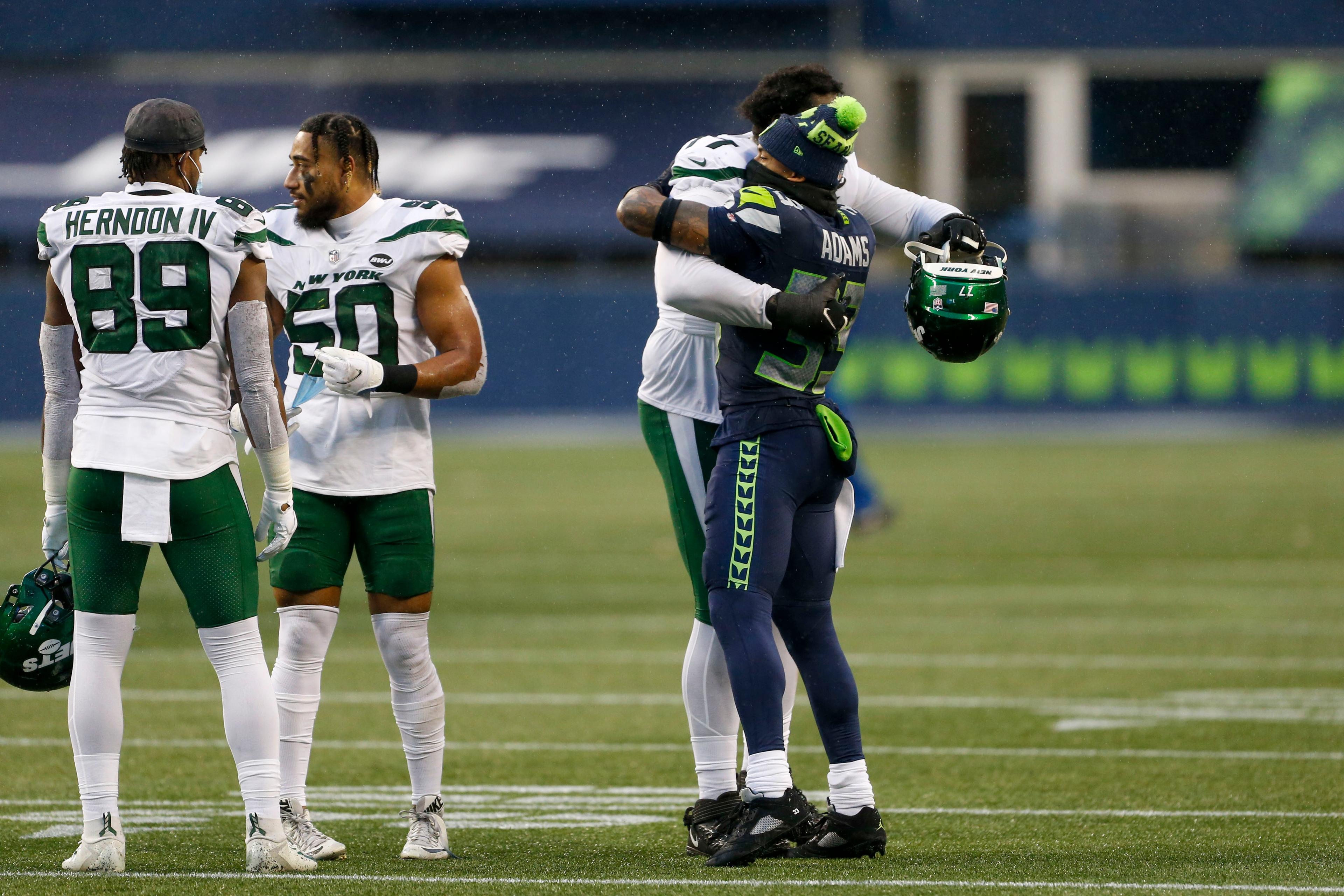 Dec 13, 2020; Seattle, Washington, USA; Seattle Seahawks strong safety Jamal Adams (33) greets New York Jets offensive tackle Mekhi Becton (77), linebacker Frankie Luvu (50) and tight end Chris Herndon (89) following a 40-3 Seattle victory at Lumen Field. Mandatory Credit: Joe Nicholson-USA TODAY Sports