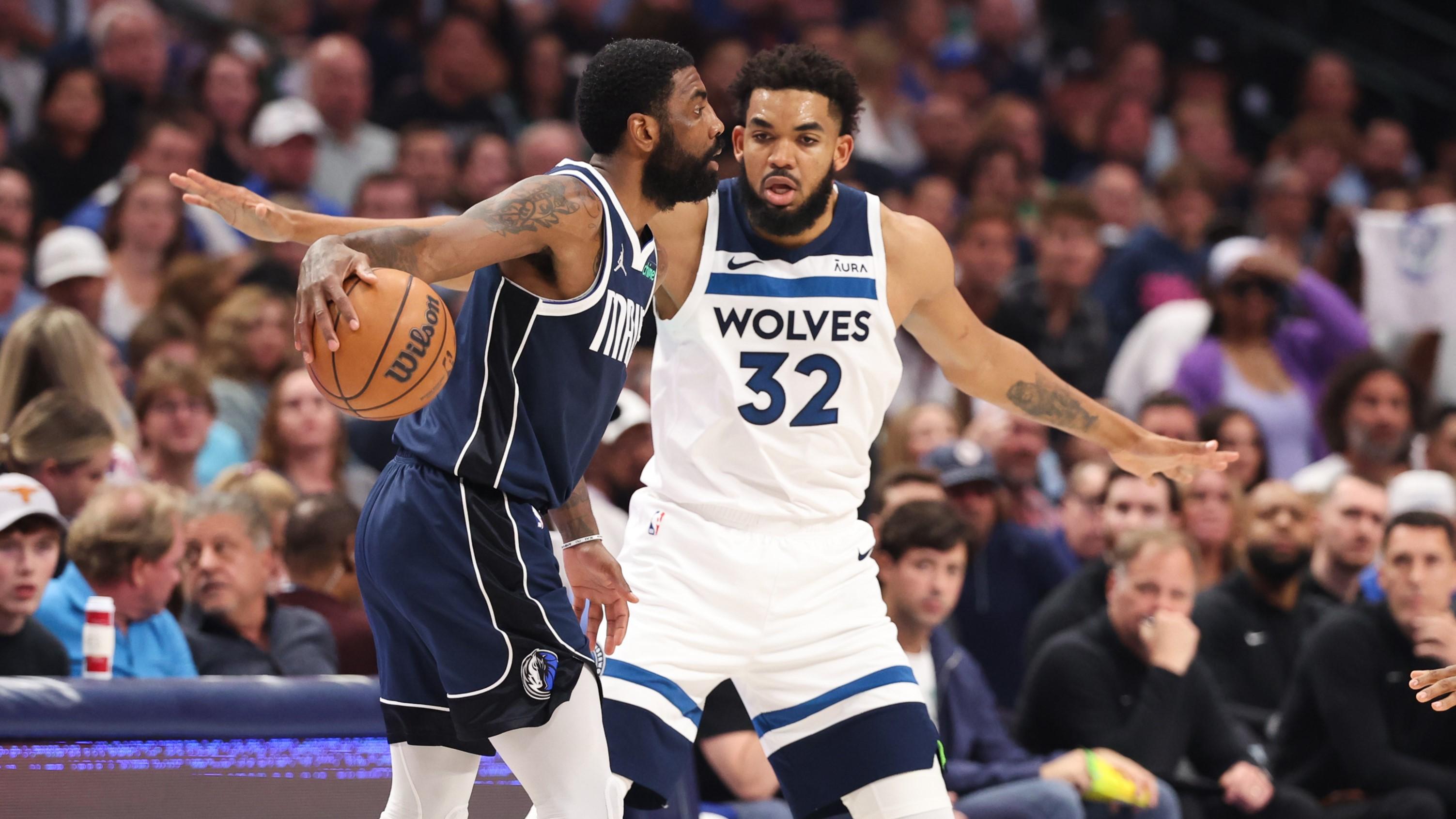 Dallas Mavericks guard Kyrie Irving (11) dribbles against Minnesota Timberwolves center Karl-Anthony Towns (32) during the first quarter of game four of the western conference finals for the 2024 NBA playoffs at American Airlines Center. 