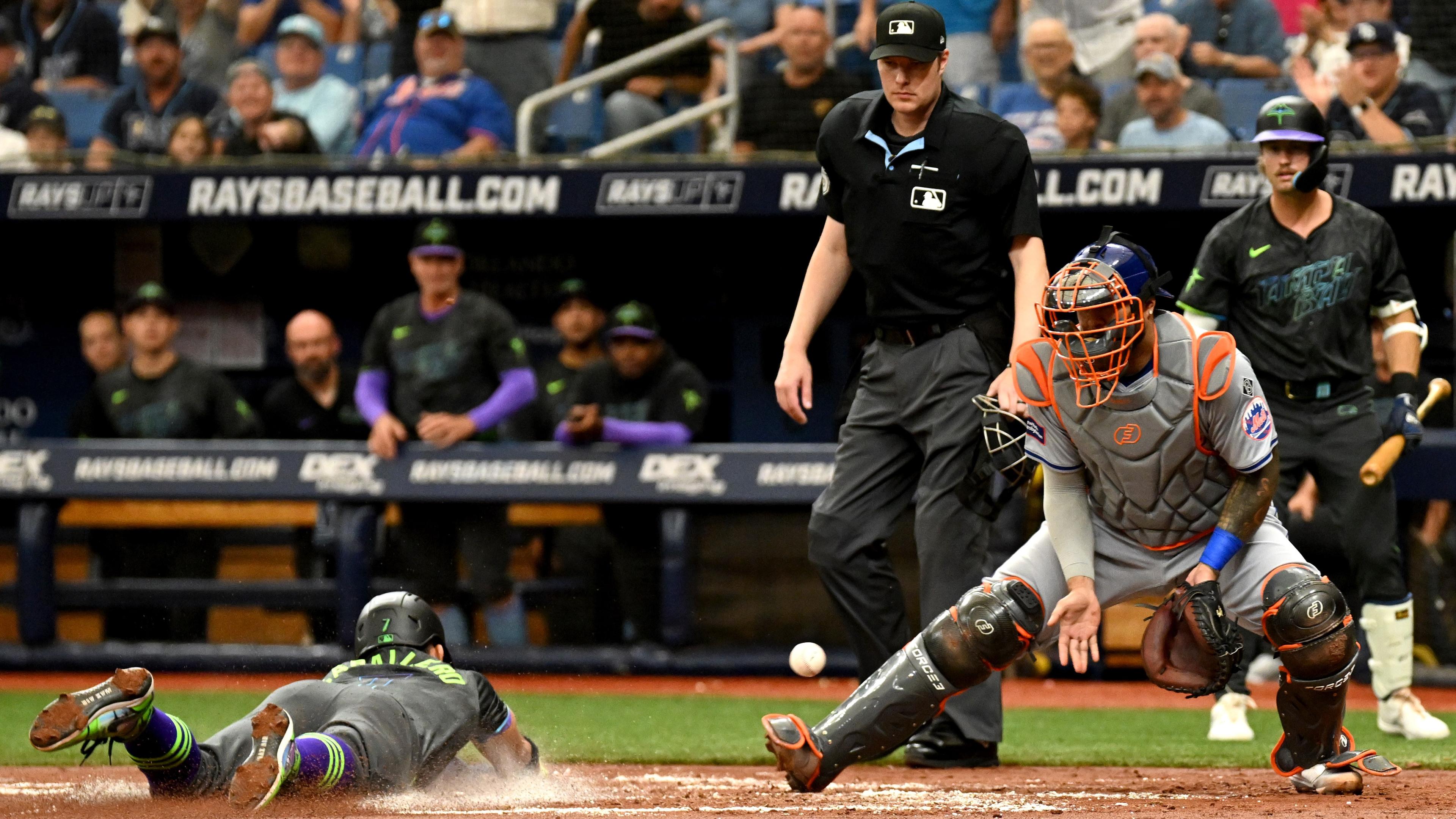 May 5, 2024; St. Petersburg, Florida, USA; New York Mets catcher Omar Narvaez (2) waits for the ball as Tampa Bay Rays shortstop Jose Caballero (7) slides to score a run in the second inning at Tropicana Field. Mandatory Credit: Jonathan Dyer-USA TODAY Sports