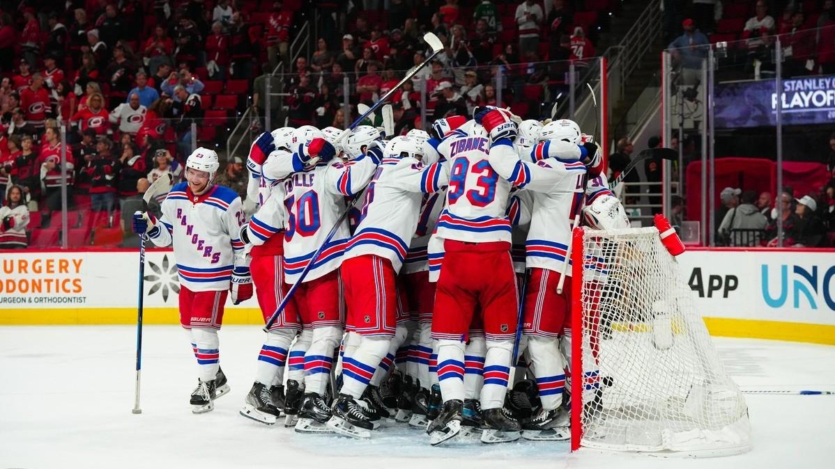 New York Rangers players celebrate their victory against the Carolina Hurricanes in game six of the second round of the 2024 Stanley Cup Playoffs at PNC Arena