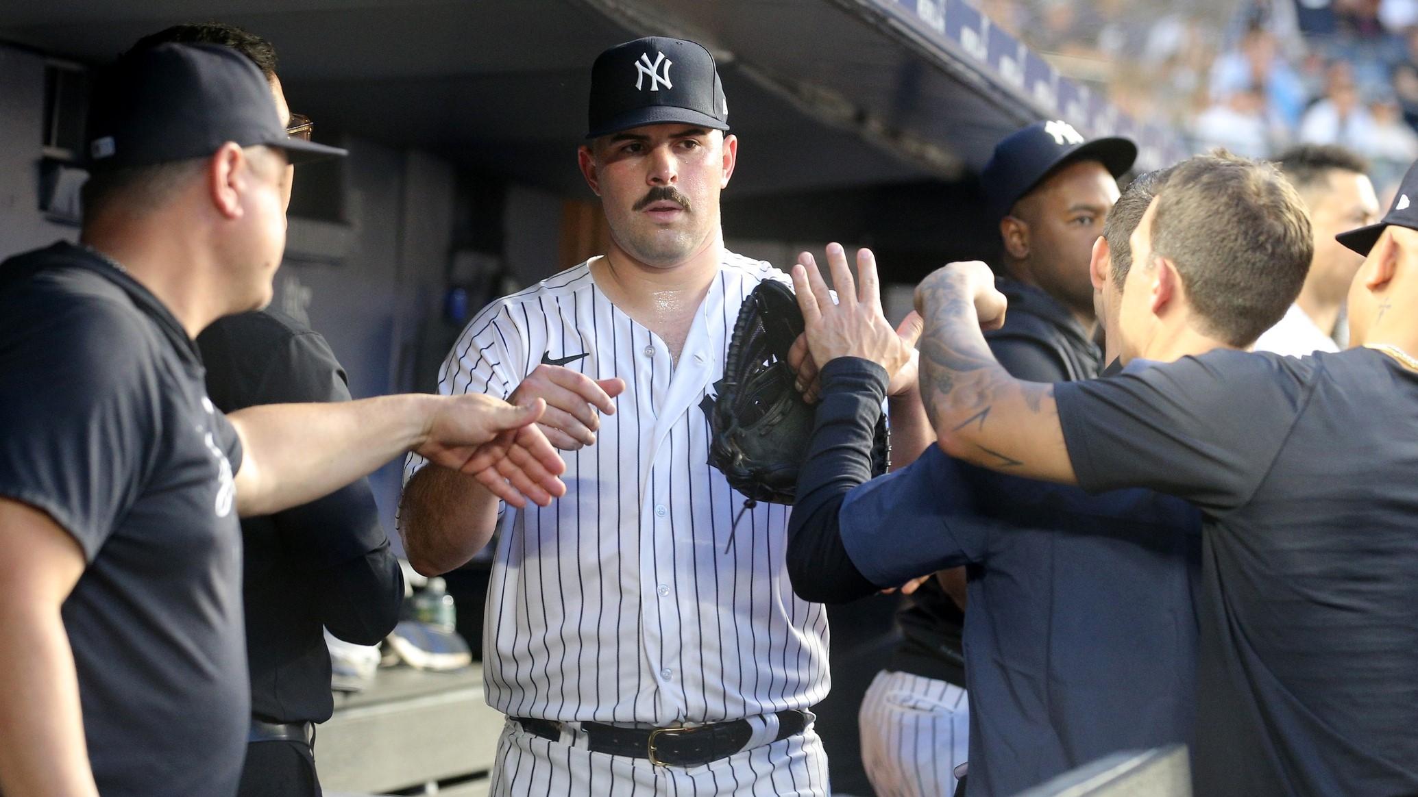 Jul 7, 2023; Bronx, New York, USA; New York Yankees starting pitcher Carlos Rodon (55) is greeted by teammates in the dugout after being taken out of the game against the Chicago Cubs during the sixth inning at Yankee Stadium.