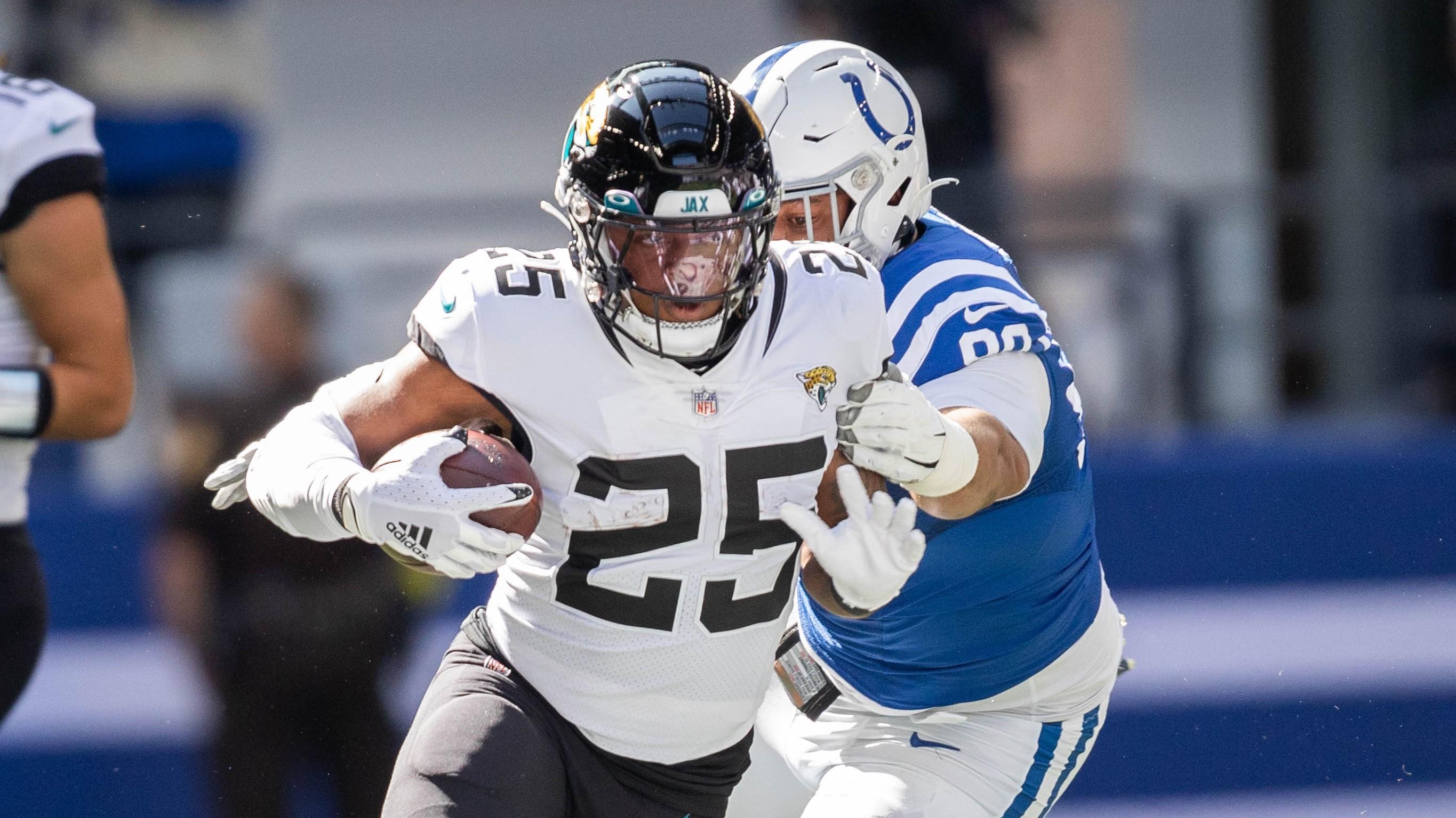 Oct 16, 2022; Indianapolis, Indiana, USA; Jacksonville Jaguars running back James Robinson (25) runs the ball while Indianapolis Colts defensive tackle Grover Stewart (90) defends in the first quarter at Lucas Oil Stadium. Mandatory Credit: Trevor Ruszkowski-USA TODAY Sports