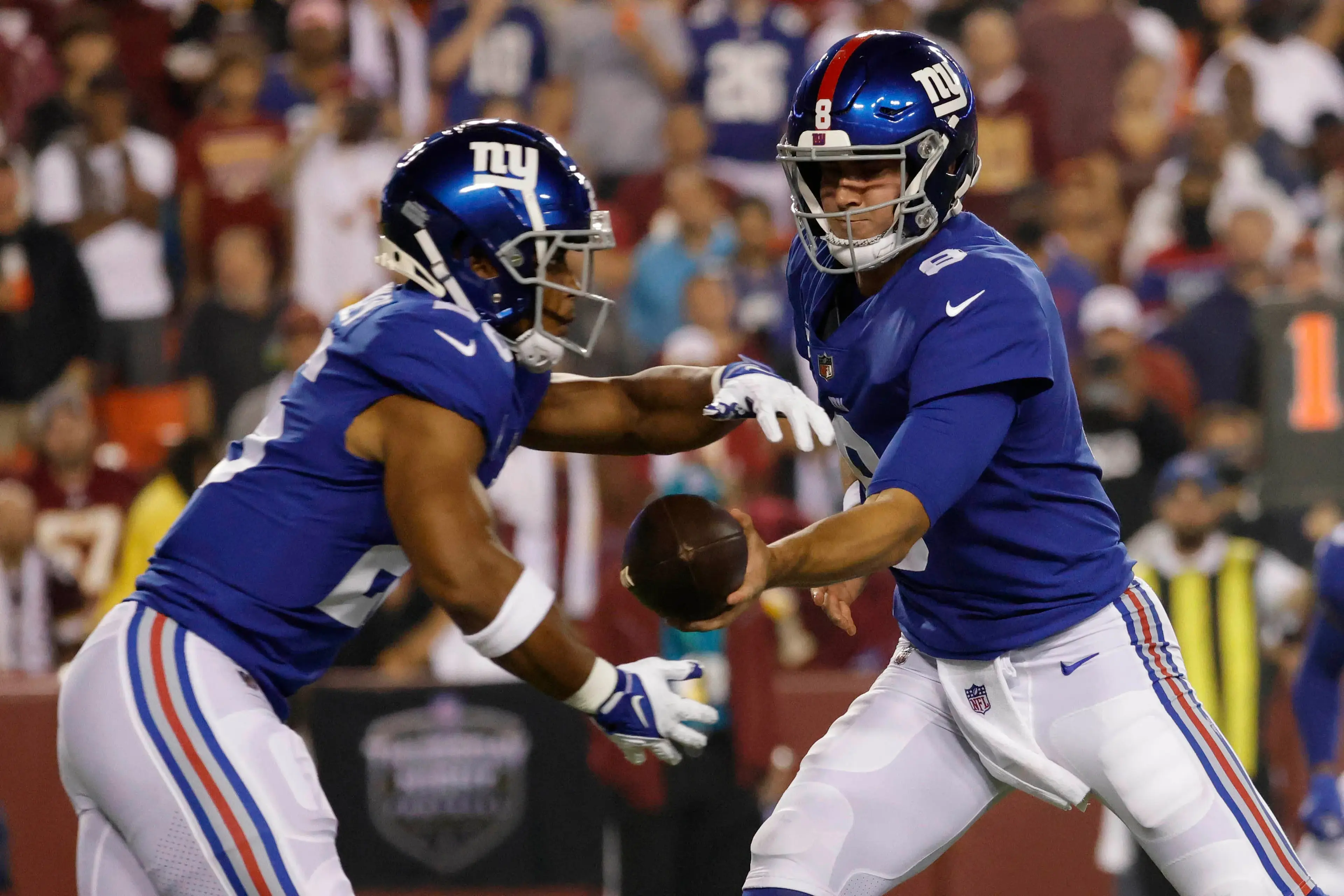 New York Giants quarterback Daniel Jones (8) hands the ball off to New York Giants running back Saquon Barkley (26) against the Washington Football Team at FedExField. / Geoff Burke - USA TODAY Sports