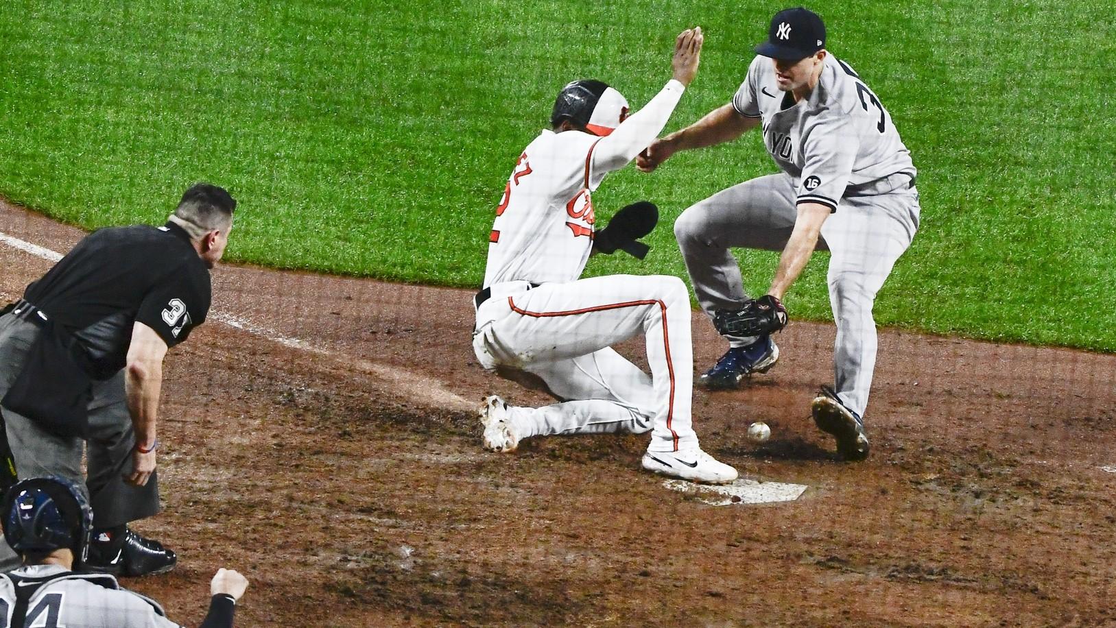 New York Yankees catcher Gary Sanchez (24) reacts as Baltimore Orioles third baseman Kelvin Gutierrez (82) slides under relief pitcher Clay Holmes (35) dropped tag attempt at home plate at Oriole Park at Camden Yards.