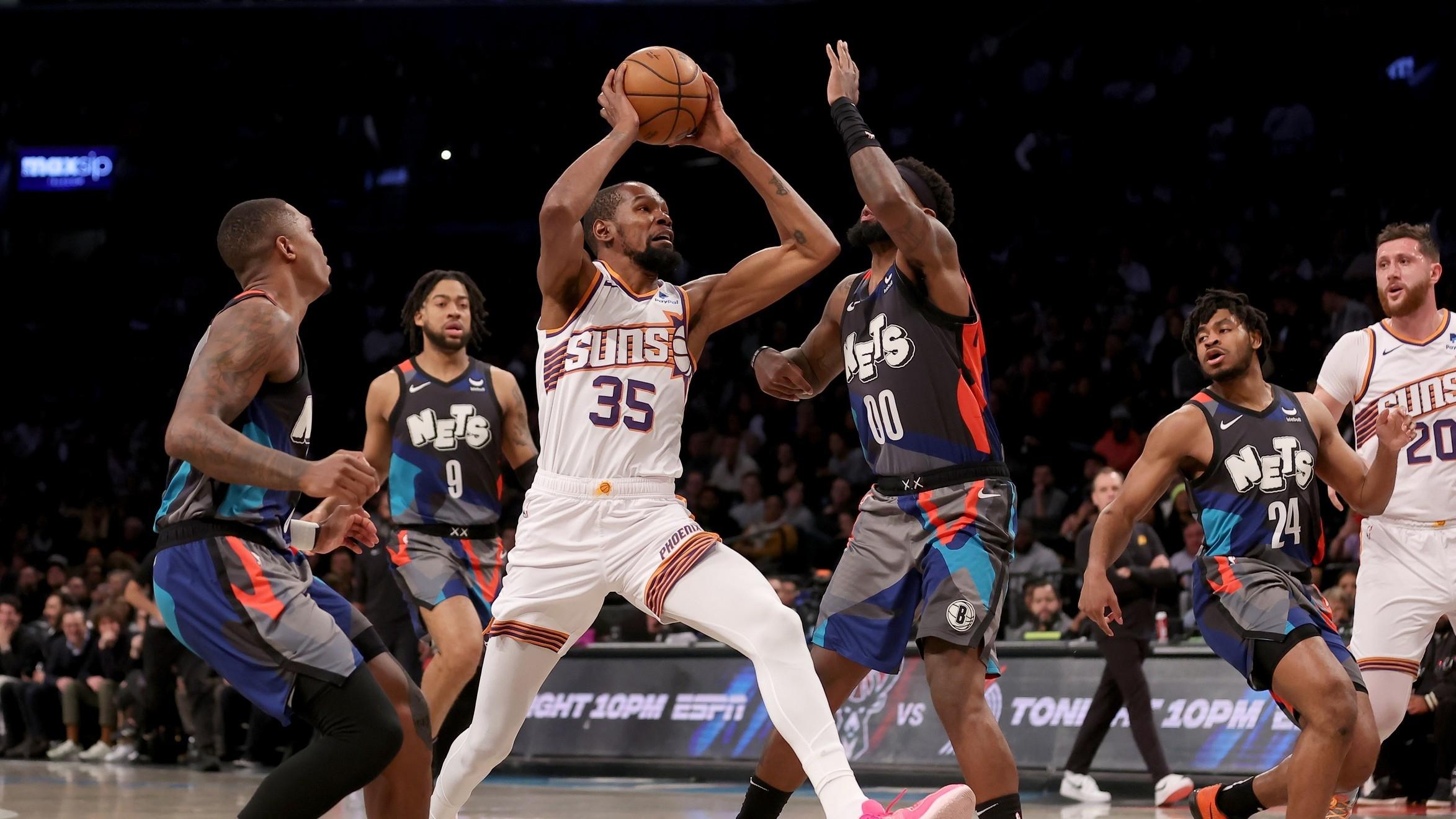 Phoenix Suns forward Kevin Durant (35) drives to the basket against Brooklyn Nets forwards Royce O'Neale (00) and Trendon Watford (9) and guard Lonnie Walker IV (8) during the first quarter at Barclays Center.