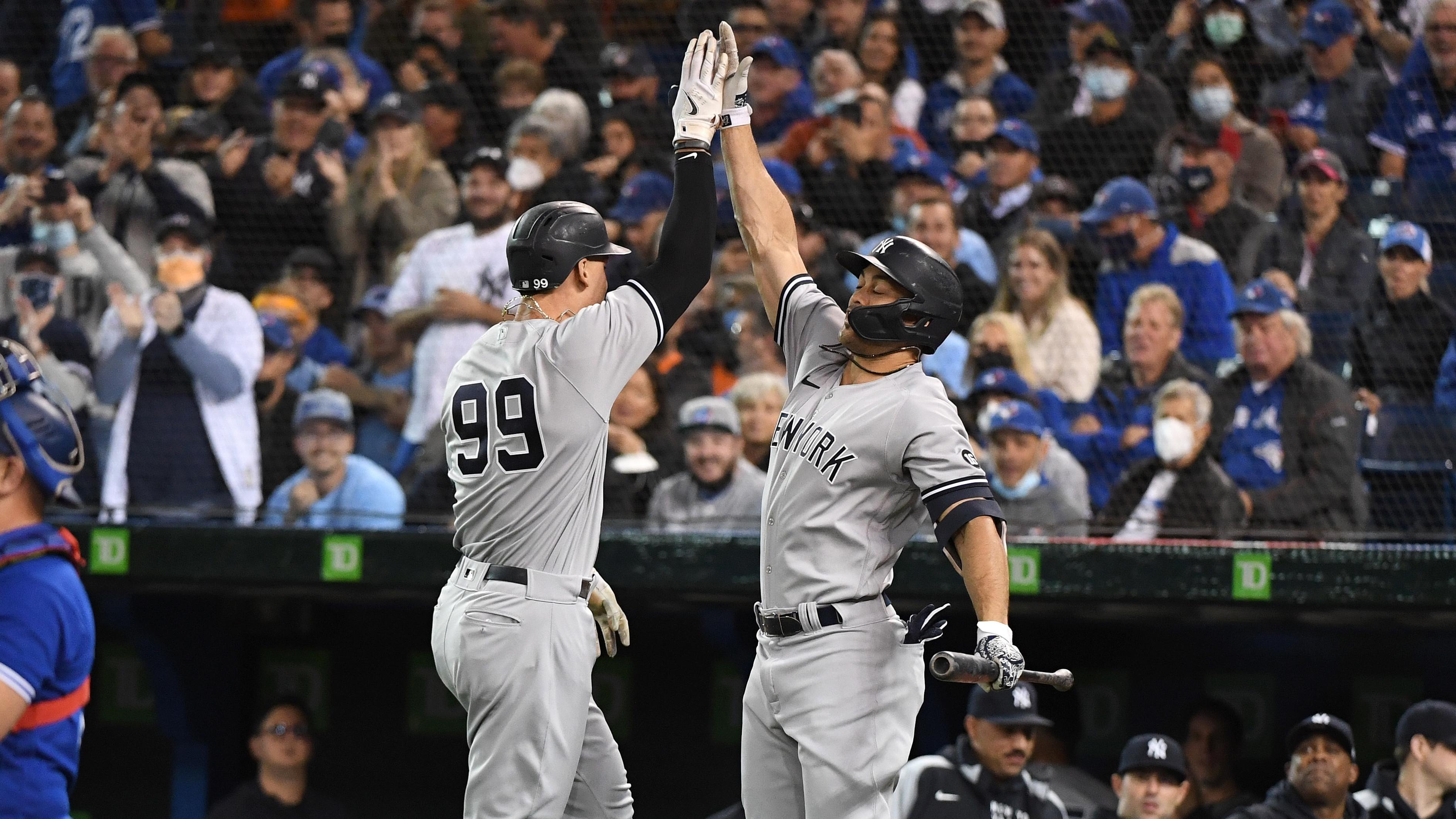 Sep 30, 2021; Toronto, Ontario, CAN; New York Yankees right fielder Aaron Judge (99) is greeted by left fielder Giancarlo Stanton (27) after hitting a solo home run against Toronto Blue Jays in the first inning at Rogers Centre.