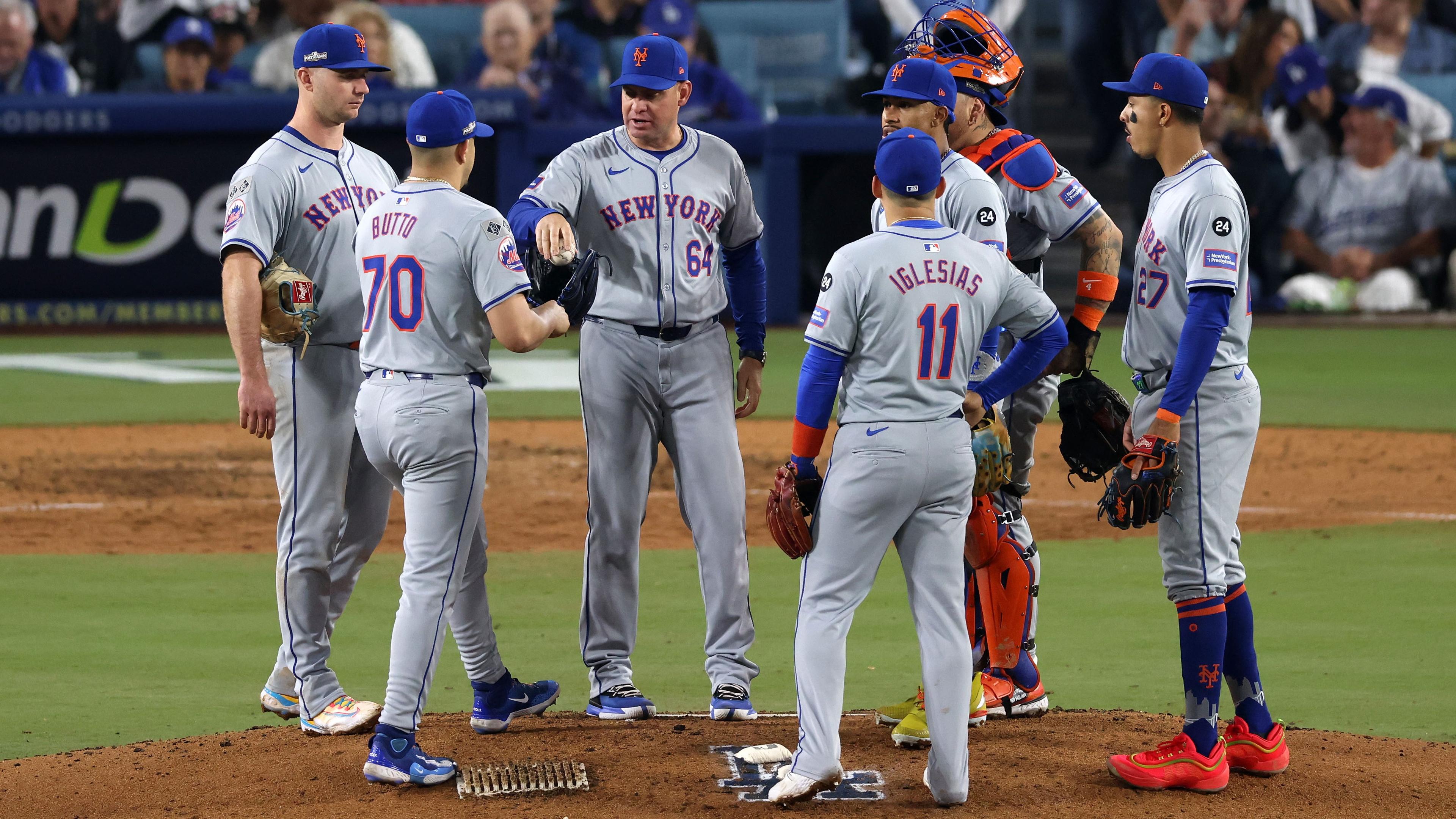 Oct 13, 2024; Los Angeles, California, USA; New York Mets manager Carlos Mendoza (64) walks to the mound to make a pitching change against the Los Angeles Dodgers in the seventh inning during game one of the NLCS for the 2024 MLB Playoffs at Dodger Stadium. 