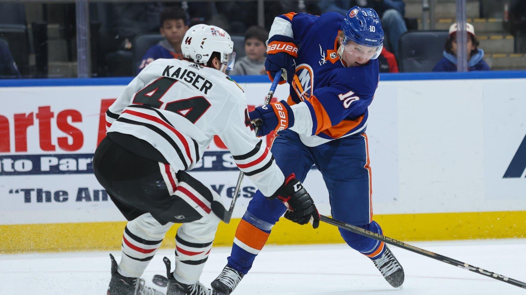 Apr 2, 2024; Elmont, New York, USA; New York Islanders right wing Simon Holmstrom (10) takes a shot while Chicago Blackhawks defenseman Wyatt Kaiser (44) pressures during the second period at UBS Arena. / Thomas Salus-USA TODAY Sports